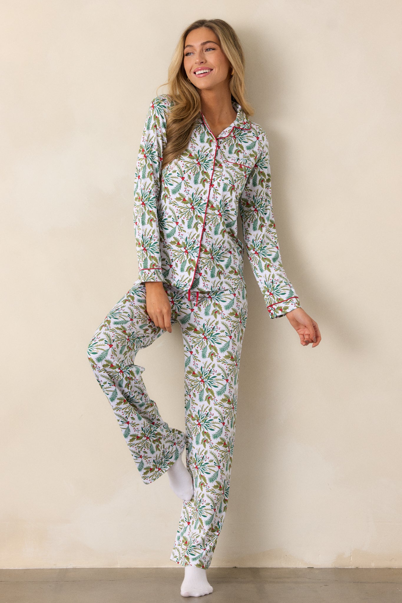 Cozy ivory pajama top with mistletoe pattern, red-trimmed collar and cuffs, a front pocket, and long sleeves