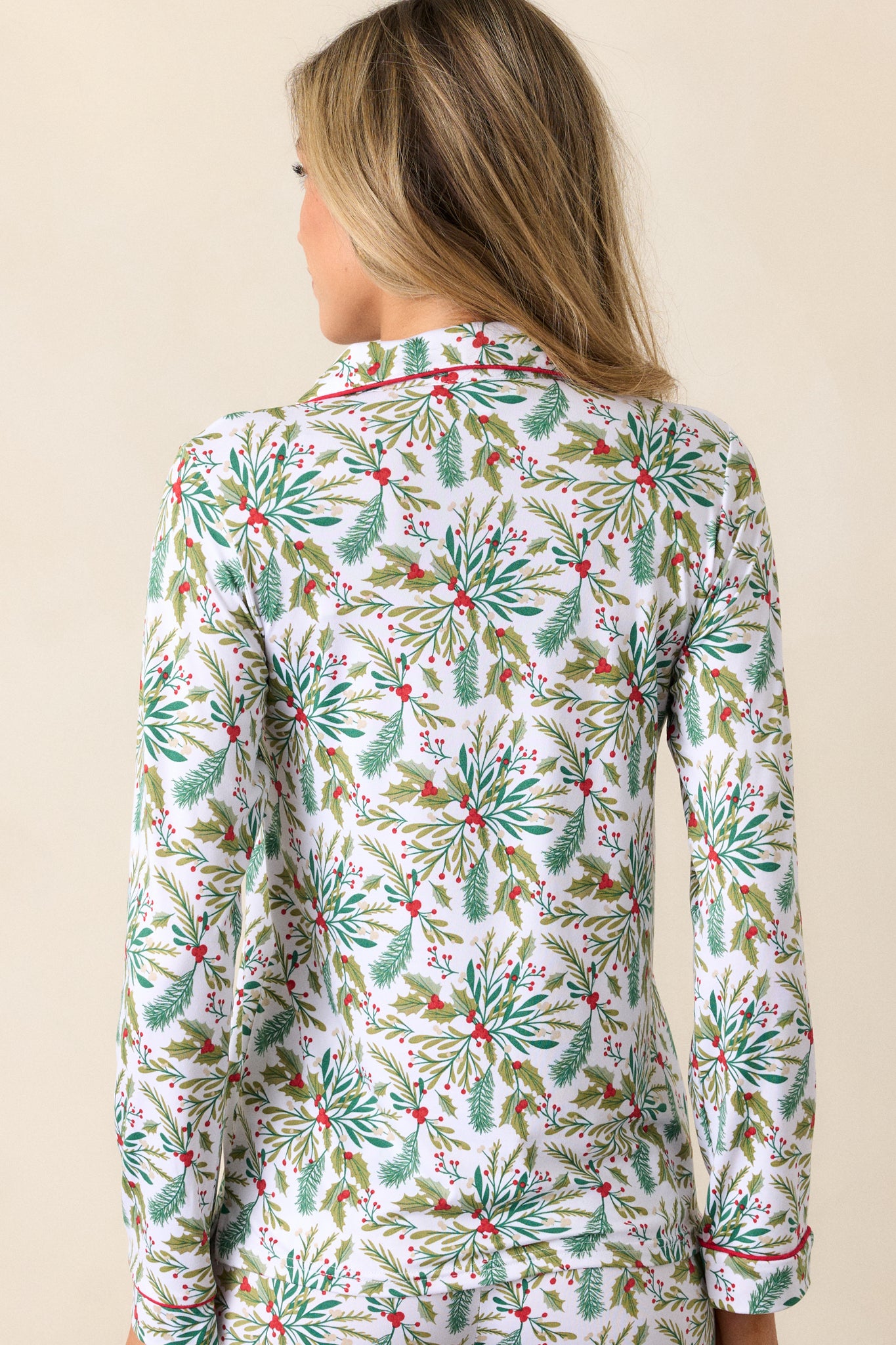 Back view of ivory pajama top with all-over mistletoe print, long sleeves, and red-trimmed details.