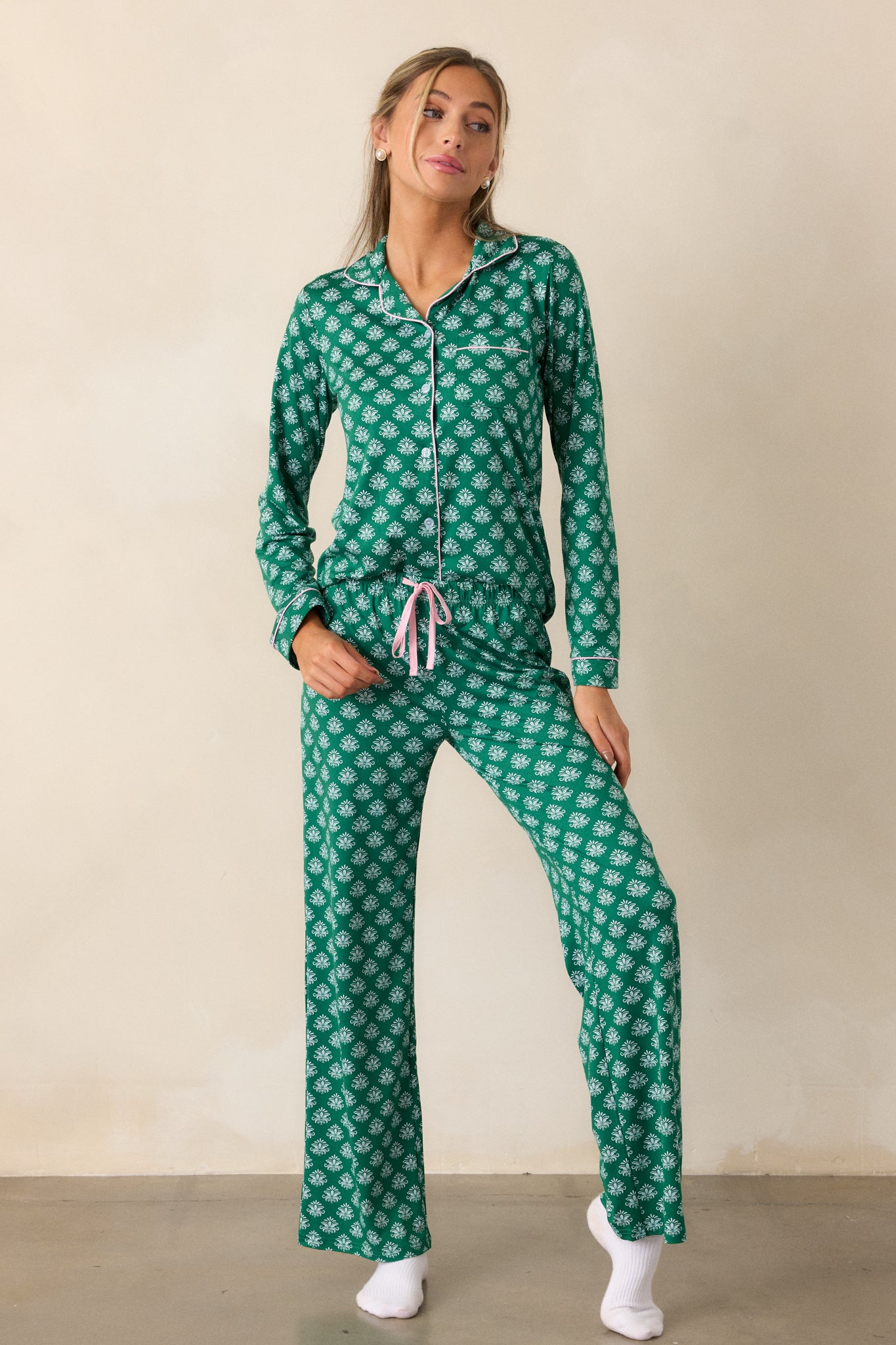 Relaxed-fit green pajama top with a Fleur de Lis pattern, button front, pink-trimmed collar, and front pocket.