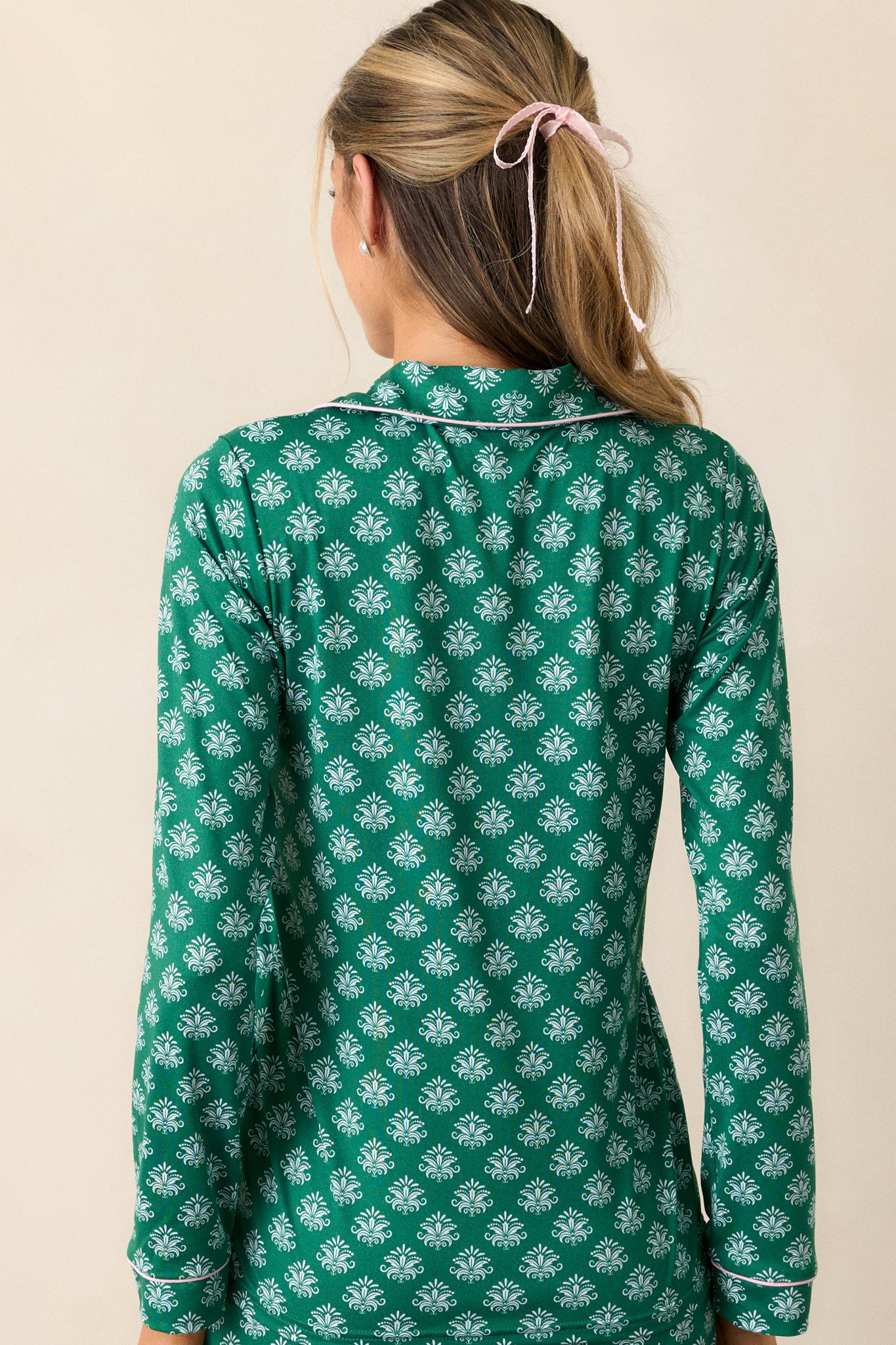 Back view of the green pajama top with relaxed fit, showing Fleur de Lis pattern and long sleeves.