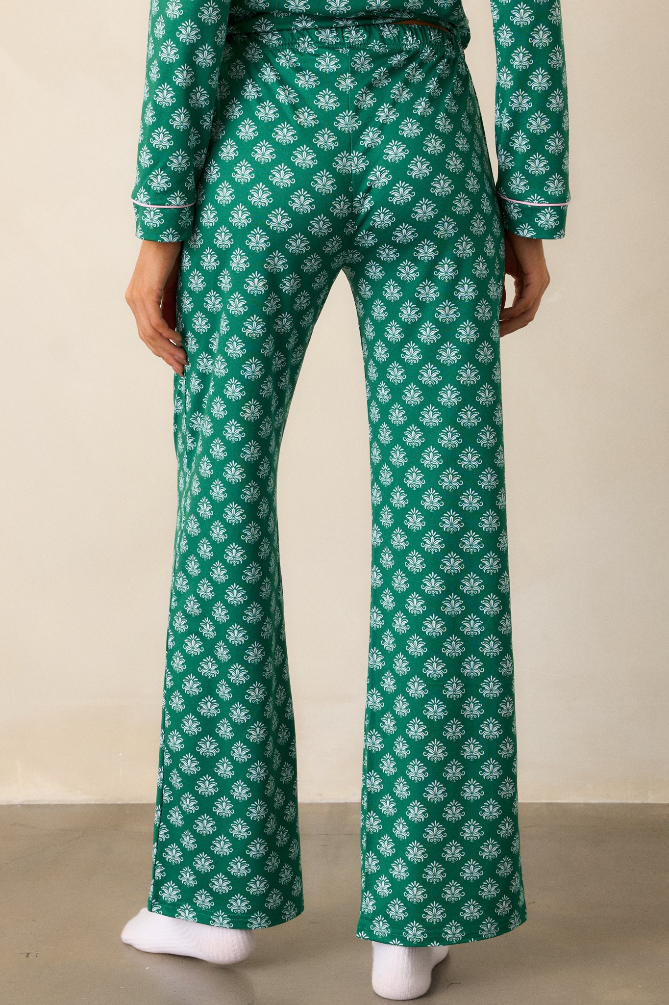 View of the back of the pajama pants, featuring the relaxed fit and the continued Fleur de Lis pattern from the waistband down to the hem.