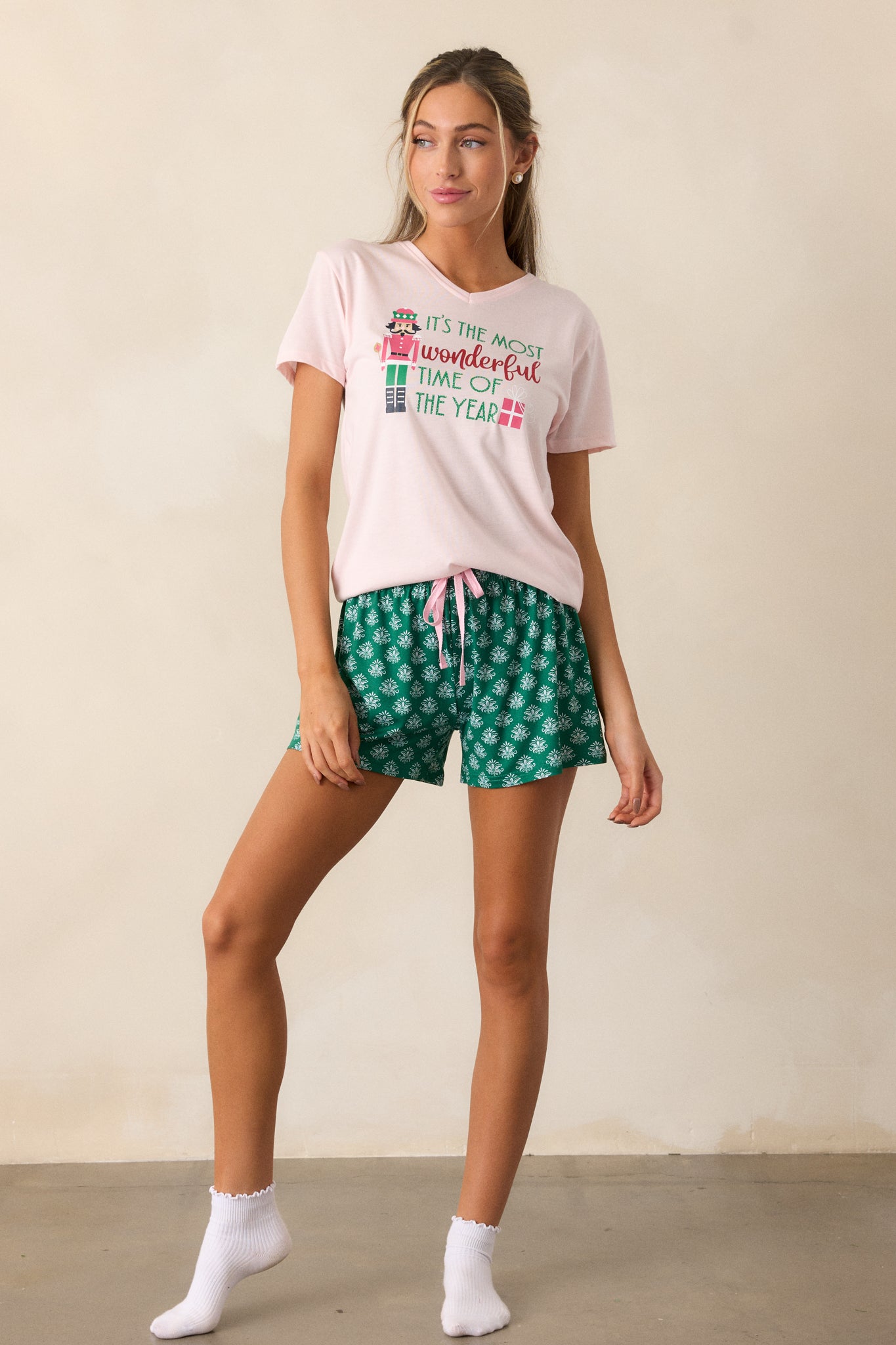 A full view of the green pajama shorts, highlighting the relaxed fit and elastic waistband with a pink tie.