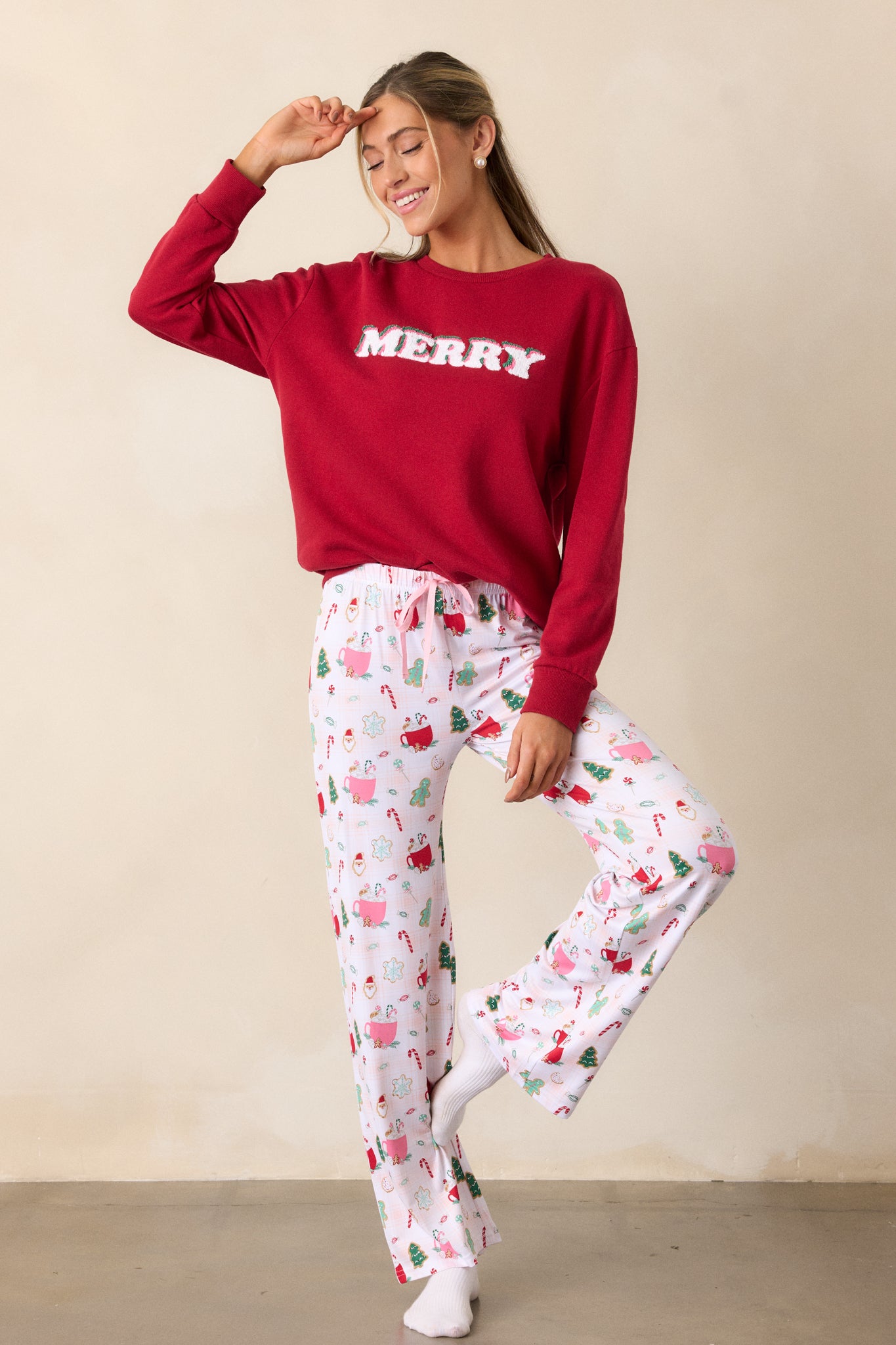 A detailed shot of the lower portion of the pants, focusing on the holiday-themed print and the relaxed fit of the long pant legs.