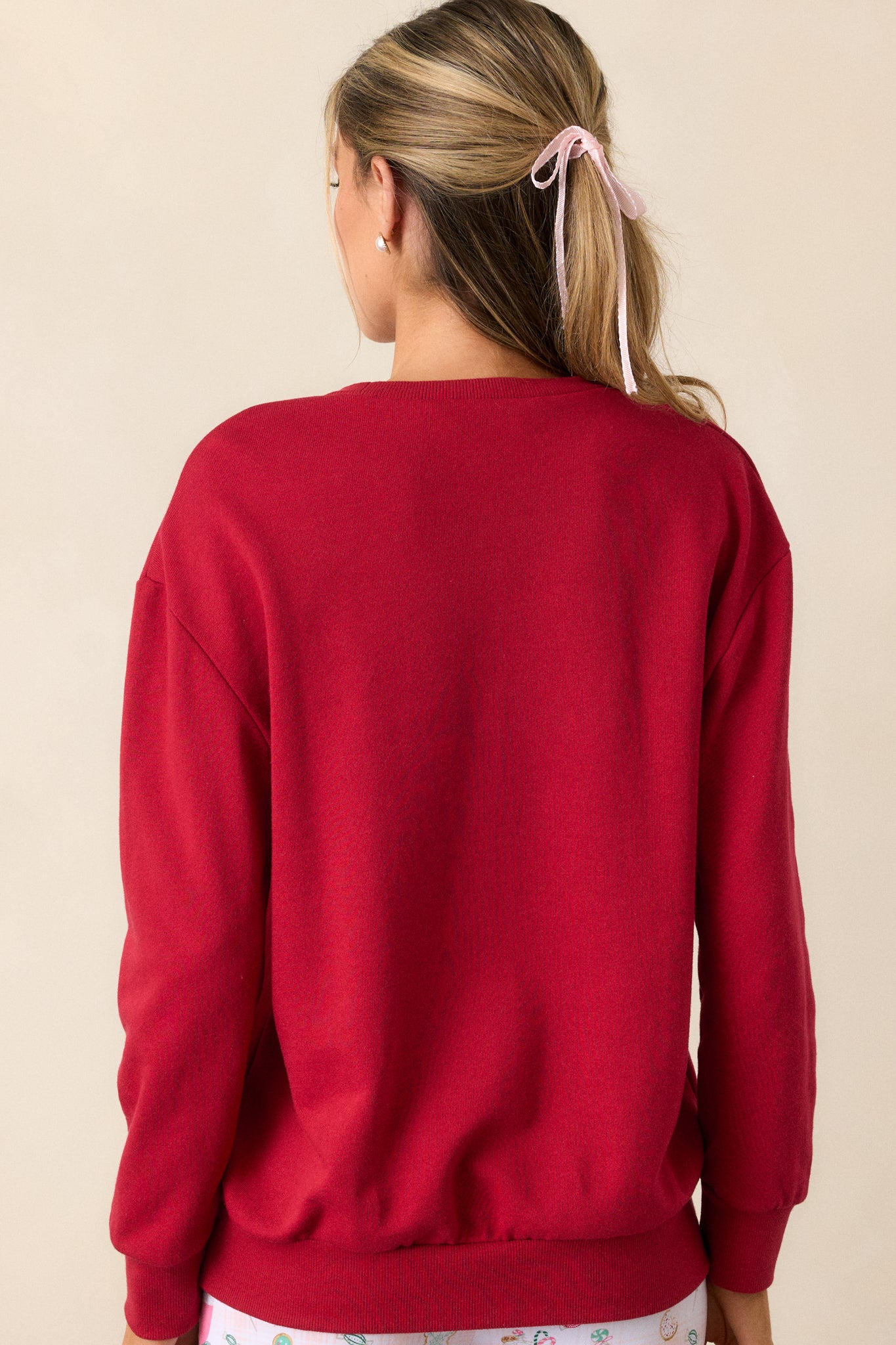 Back detail view of the red sweatshirt, emphasizing the relaxed silhouette and the smooth finish of the fabric.