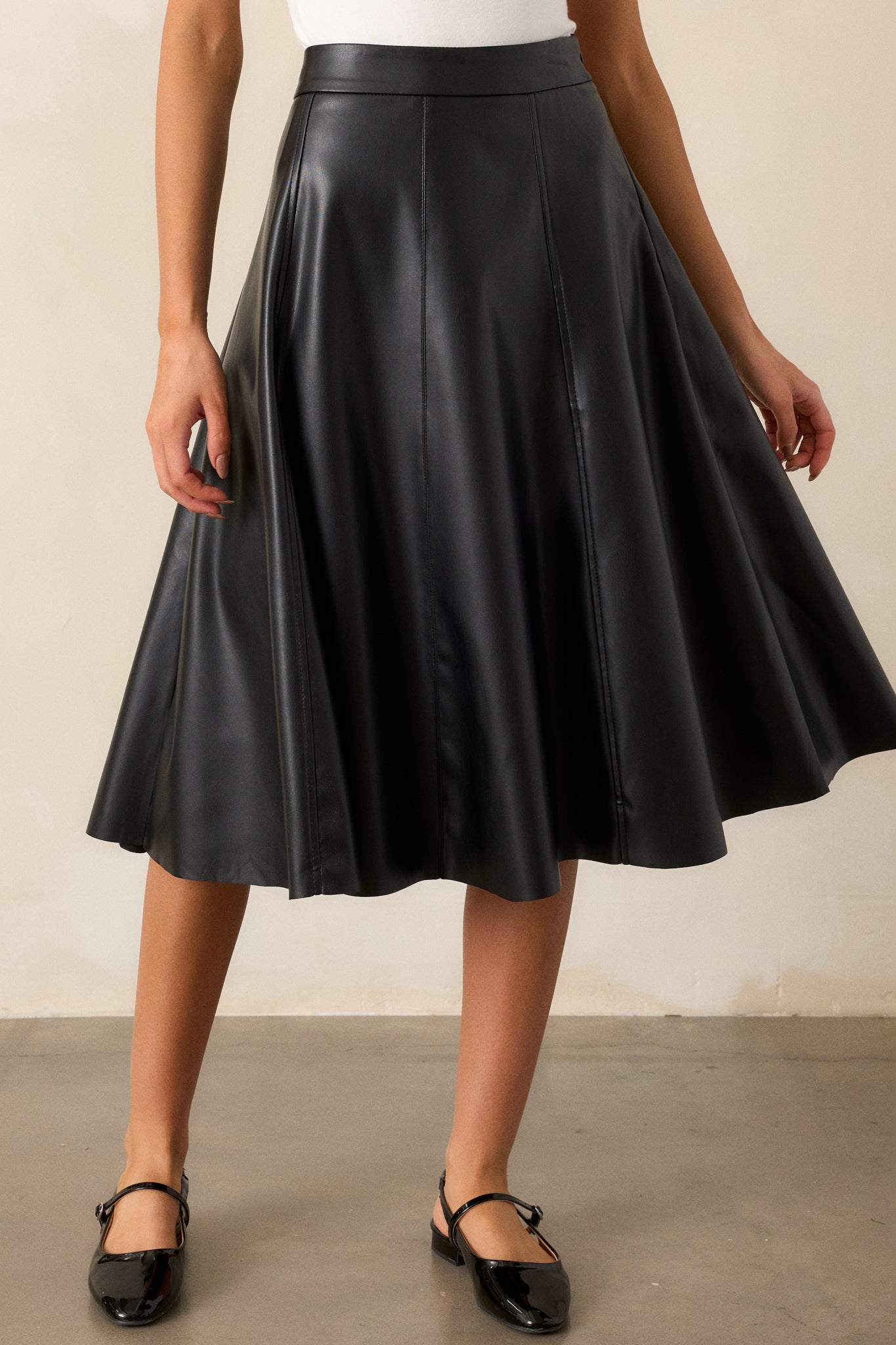 Front view of the skirt showcasing the A-line silhouette, with a focus on the side zipper and the sleek faux leather material