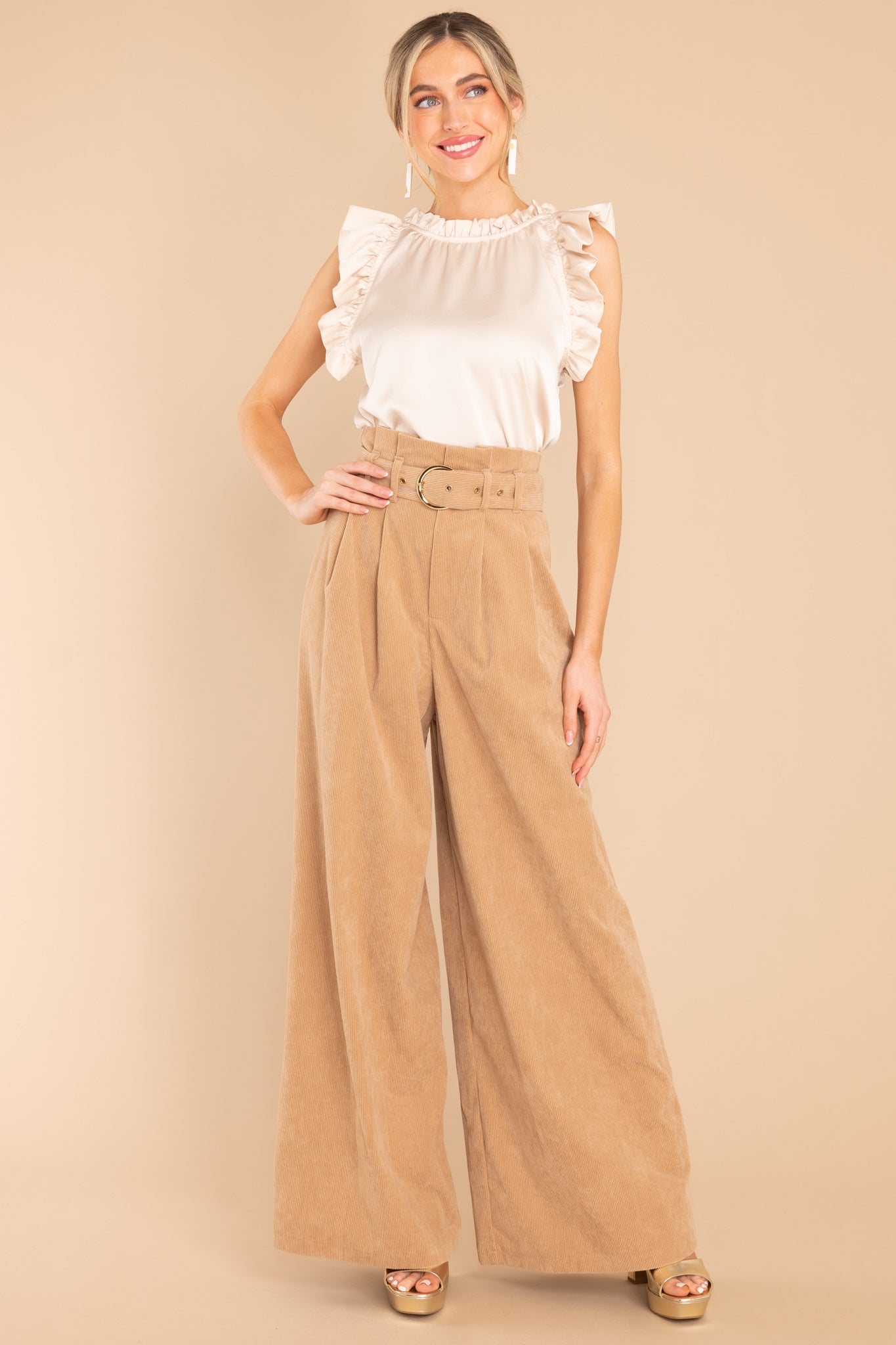 These tan pants feature a paper bag style waistline, an adjustable belt, a zipper closure, and very flowy legs.