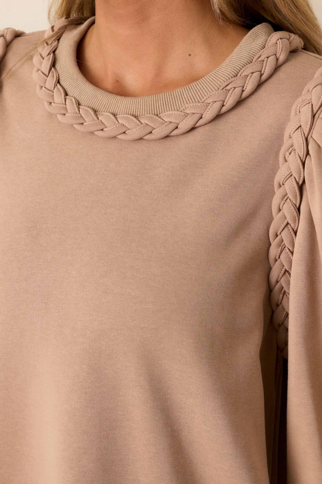 Detail shot of the braided crew neckline and braided detailing on the shoulders. 