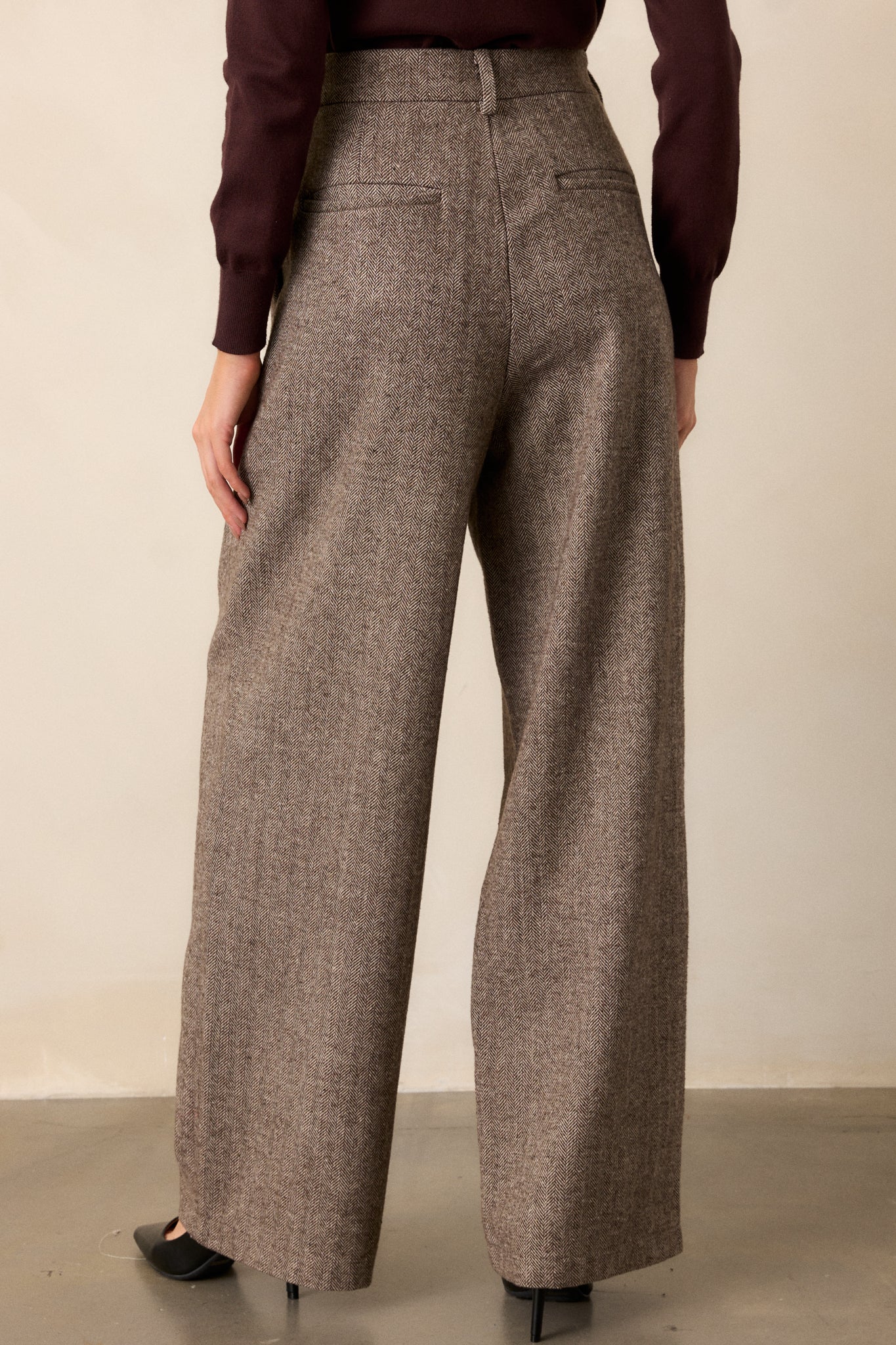 Rear view of the brown herringbone pants, highlighting the functional back pockets and waistband details.