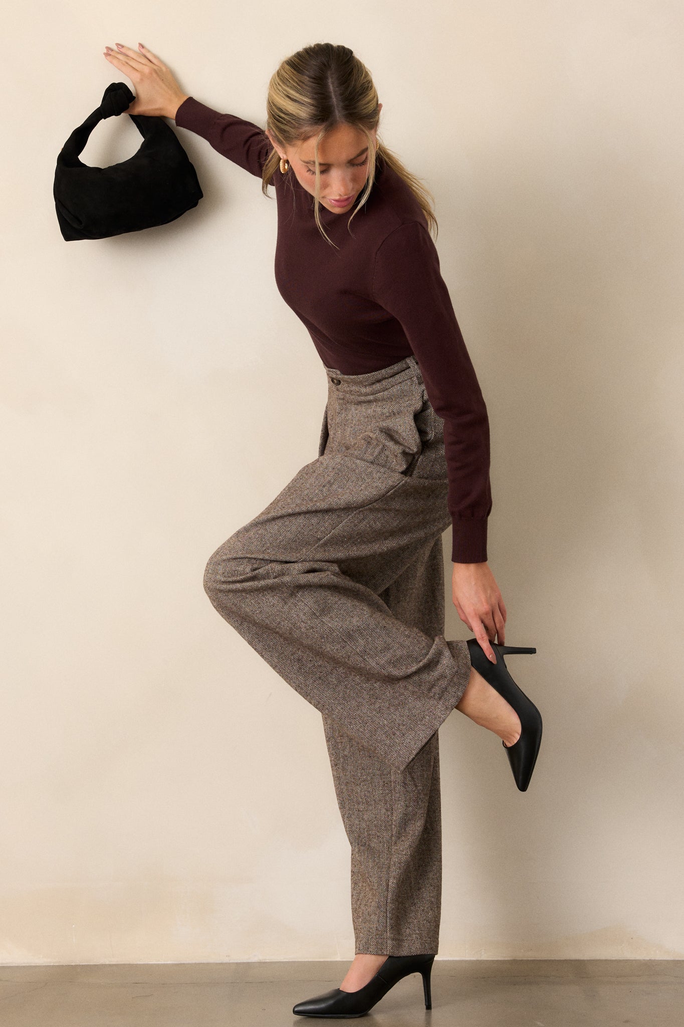 Side view of brown herringbone pants, highlighting the straight-leg cut and textured fabric design from hip to ankle.