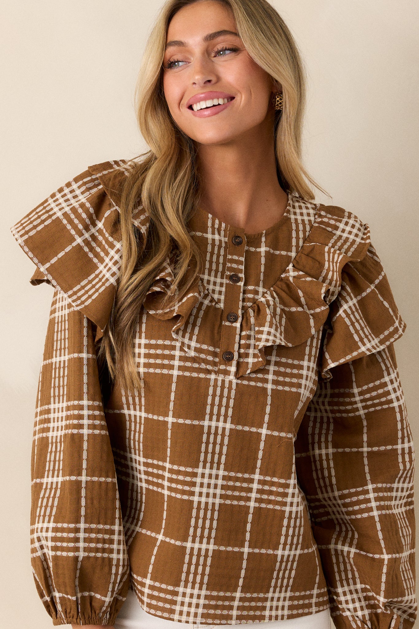 A detailed view of the ruffle accents along the shoulders and front, emphasizing the texture and design against the plaid pattern.