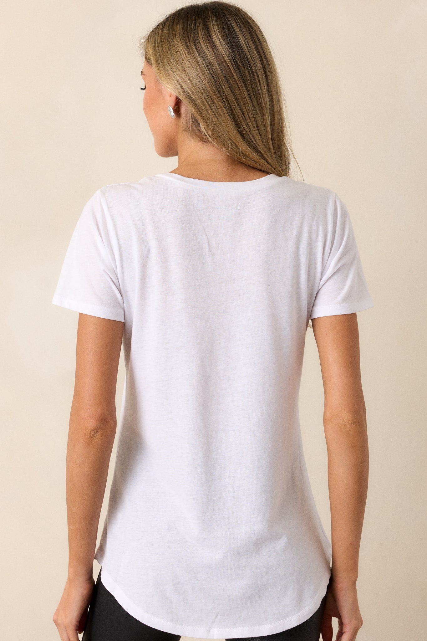 Back view of a white tee highlighting the super soft fabric and scooped hemline.