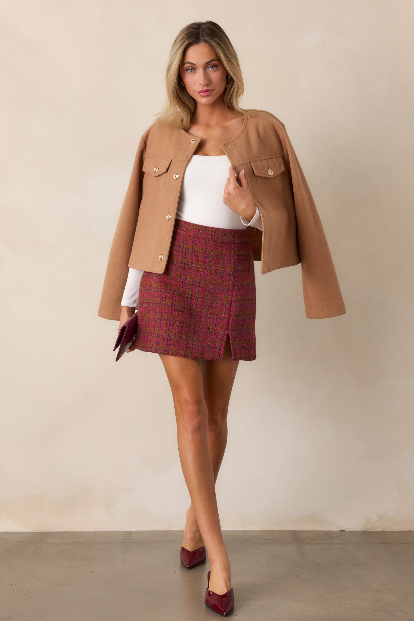 Full view of the dark sangria mini skirt with a high waist, showcasing its multicolor tweed fabric and small front slit.