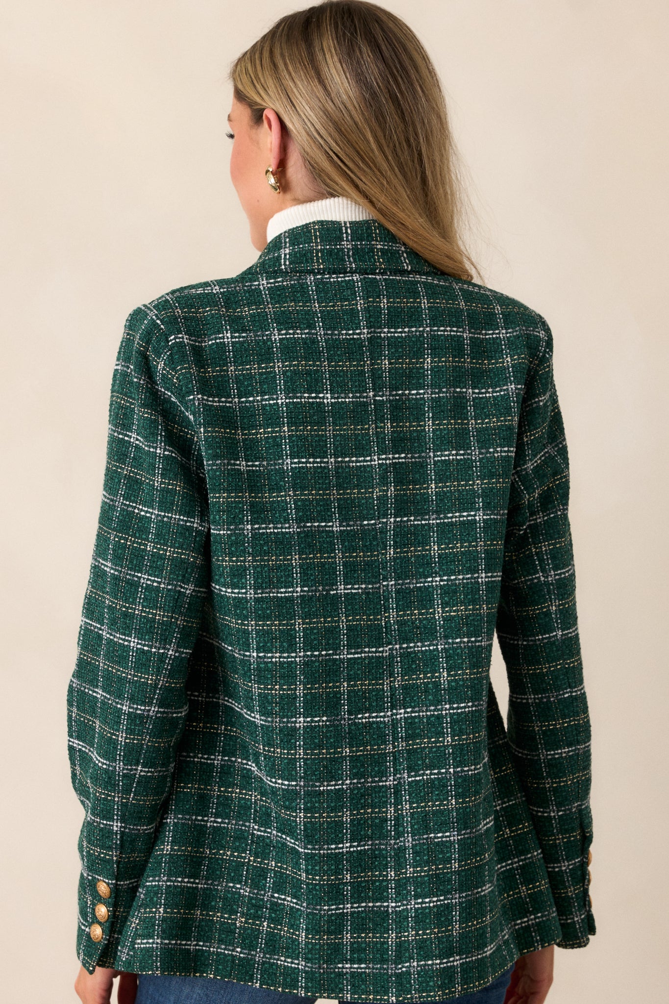 Back view of the coat, showcasing the full tailored design and the rich forest green tweed fabric with subtle gold and white stitching.