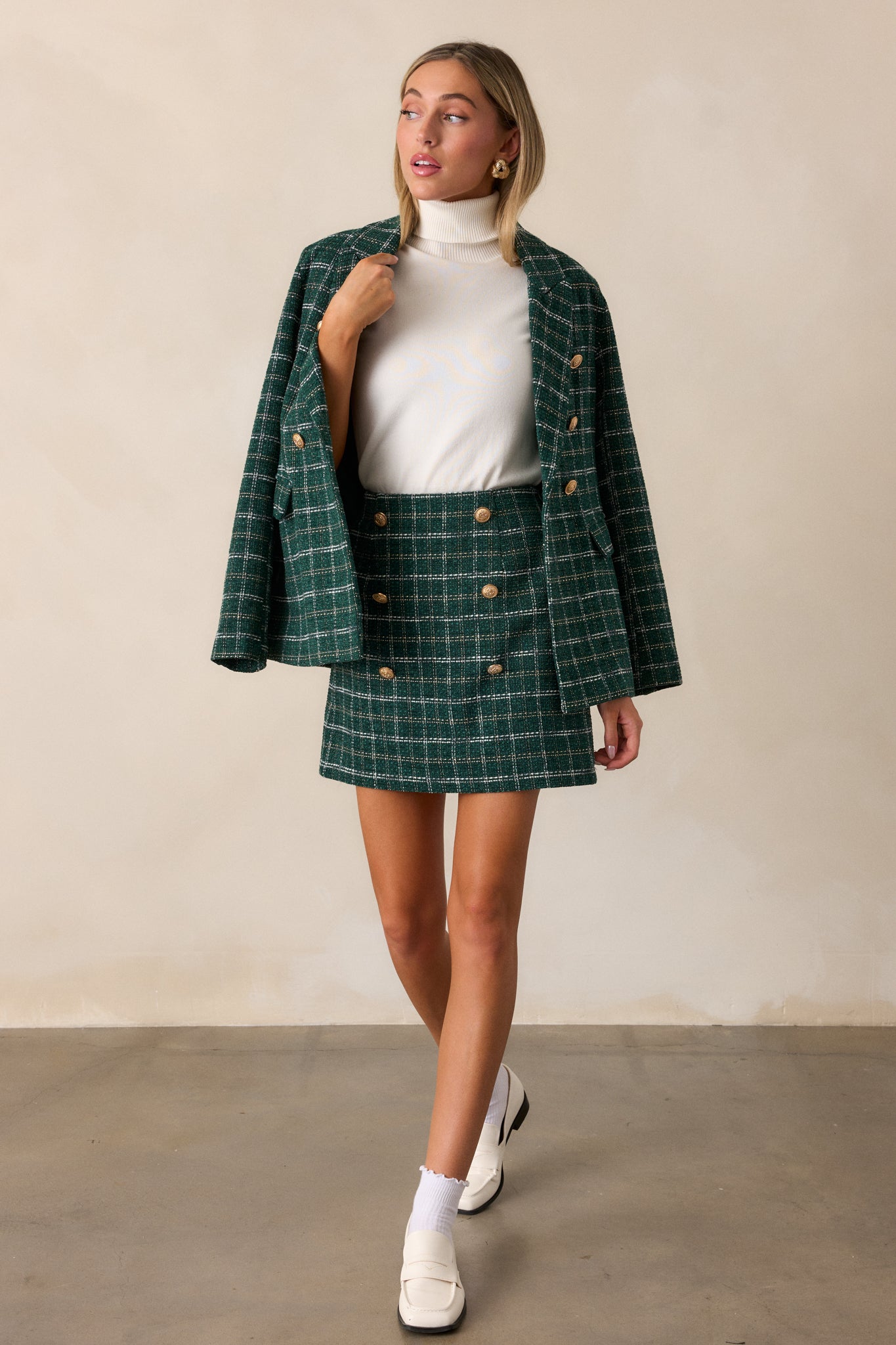 Full-length view of the forest green mini skirt, showcasing the fitted silhouette and rich tweed texture with subtle gold and white stitching.