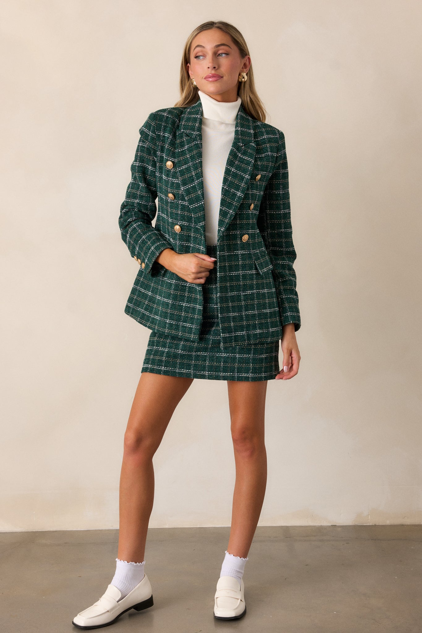 Full-length view of the forest green tweed coat, highlighting the tailored fit, gold embellished buttons, and buttoned cuffs on the long sleeves.