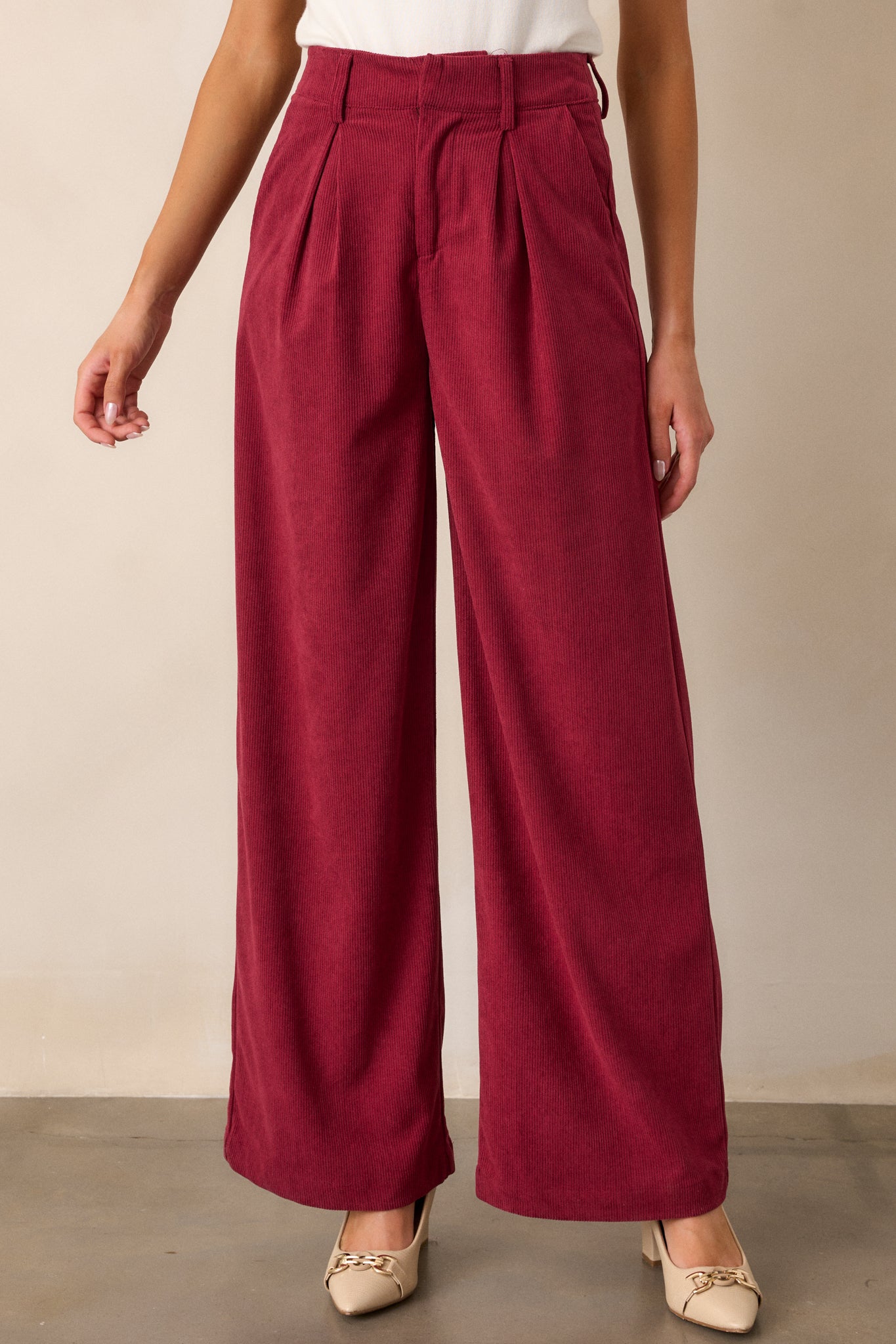 Partial view of cranberry pants, highlighting the textured corduroy-like material on the front leg area.