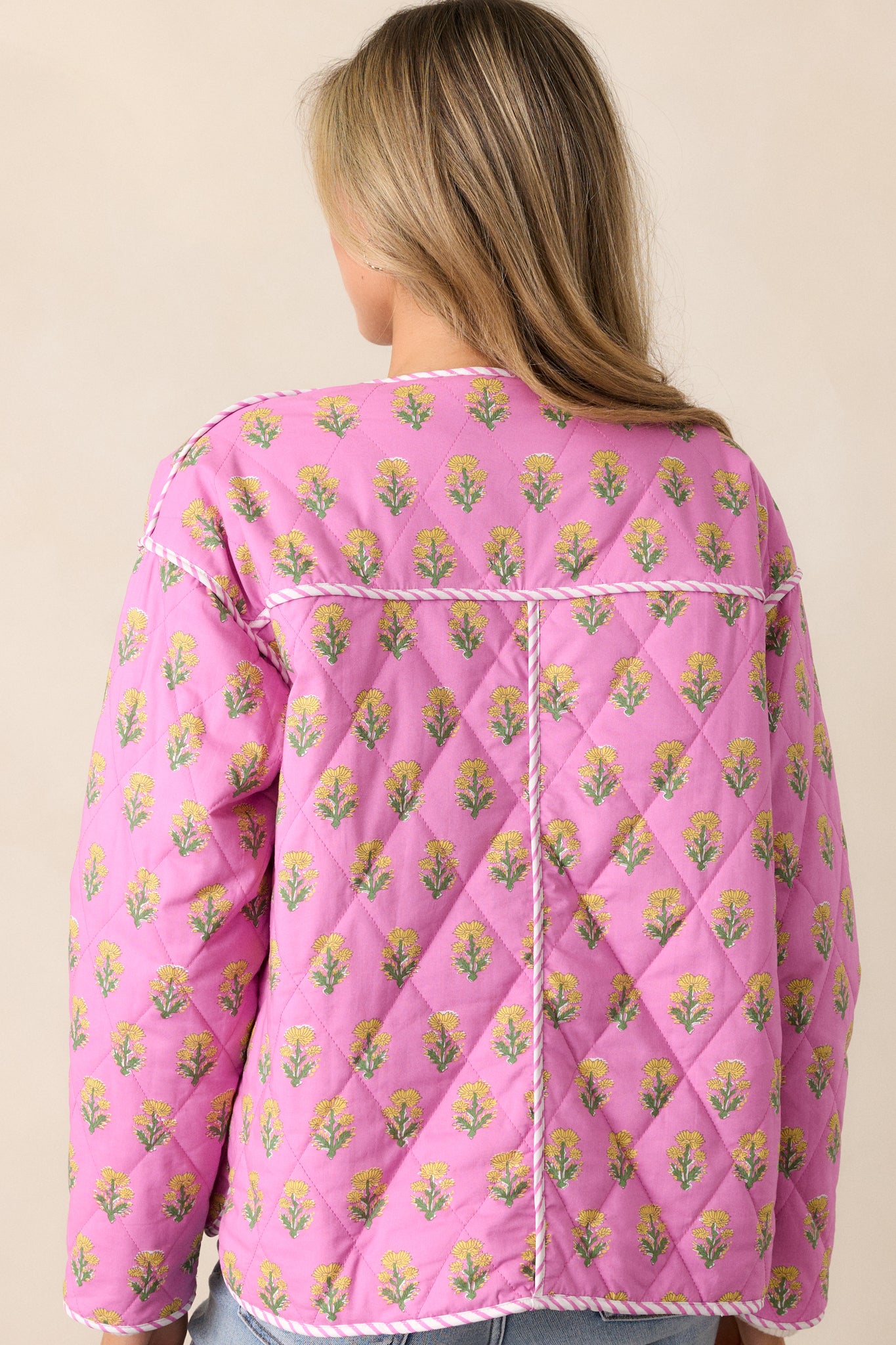 The back of the pink floral jacket, featuring an uninterrupted floral pattern and subtle tailoring details.