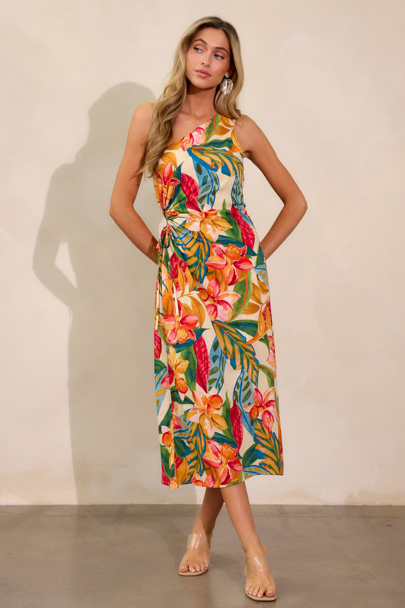 Full view of a multi-print dress with an asymmetric neckline, one-shoulder design, and a flowing silhouette, featuring a self-tie cut-out detail on the side