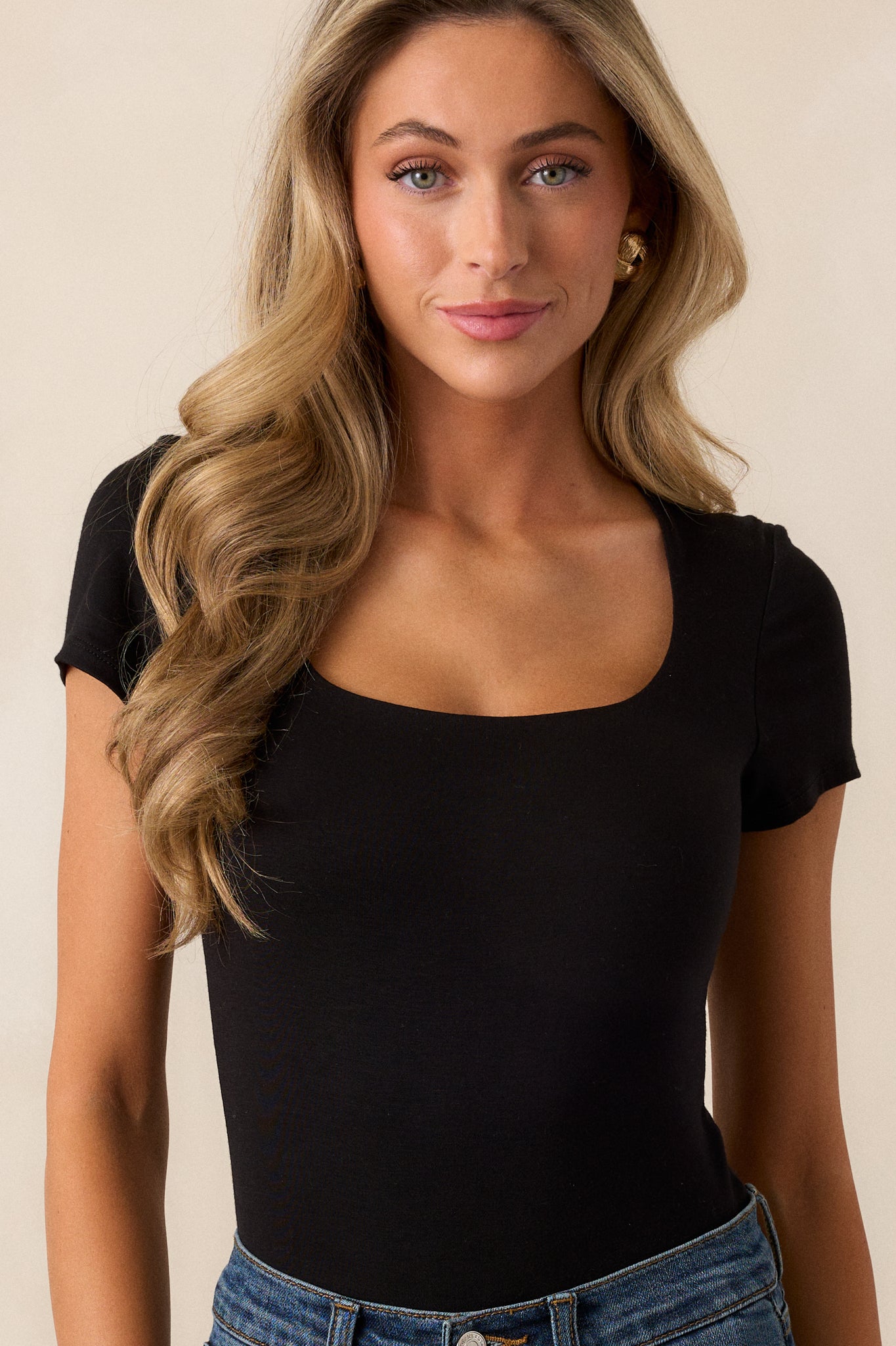 Front view of the black bodysuit showcasing the scoop neckline, short sleeves, and the smooth fit along the torso.