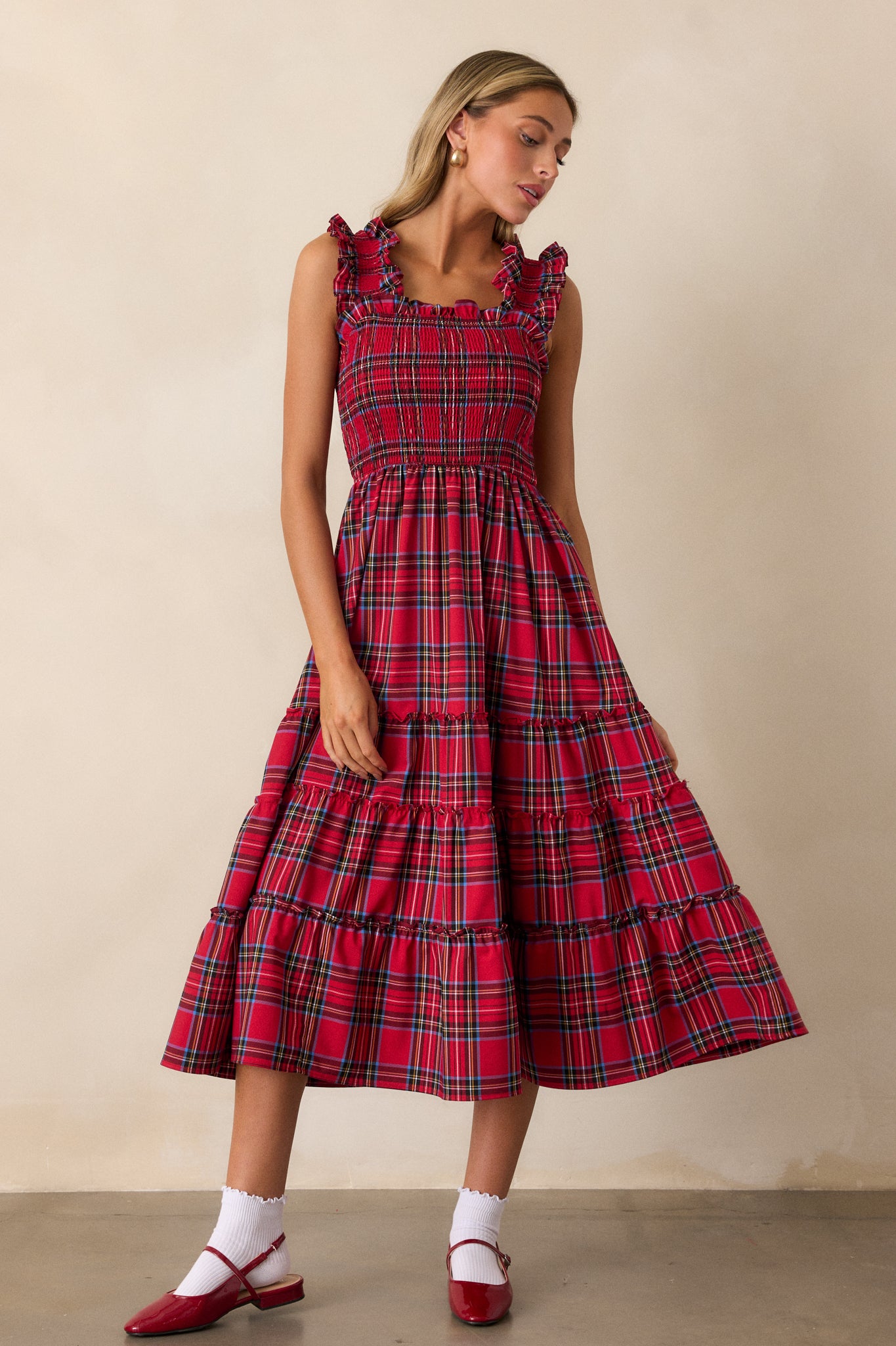 Full body view of this dress that features thick ruffle straps, smocked bodice, and a tiered skirt. 