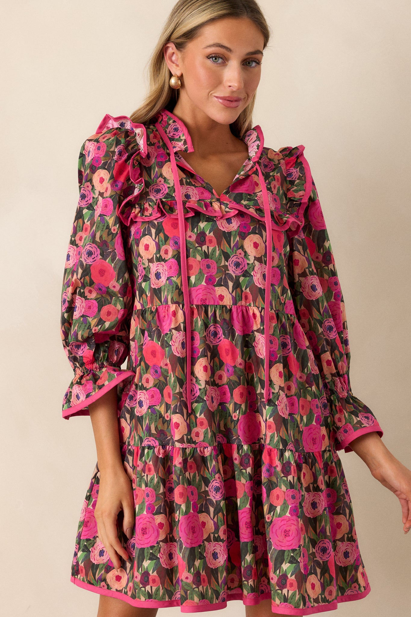 Zoomed-in view showing the ruffled shoulder and yoke details along with the pink seams on the floral mini dress.