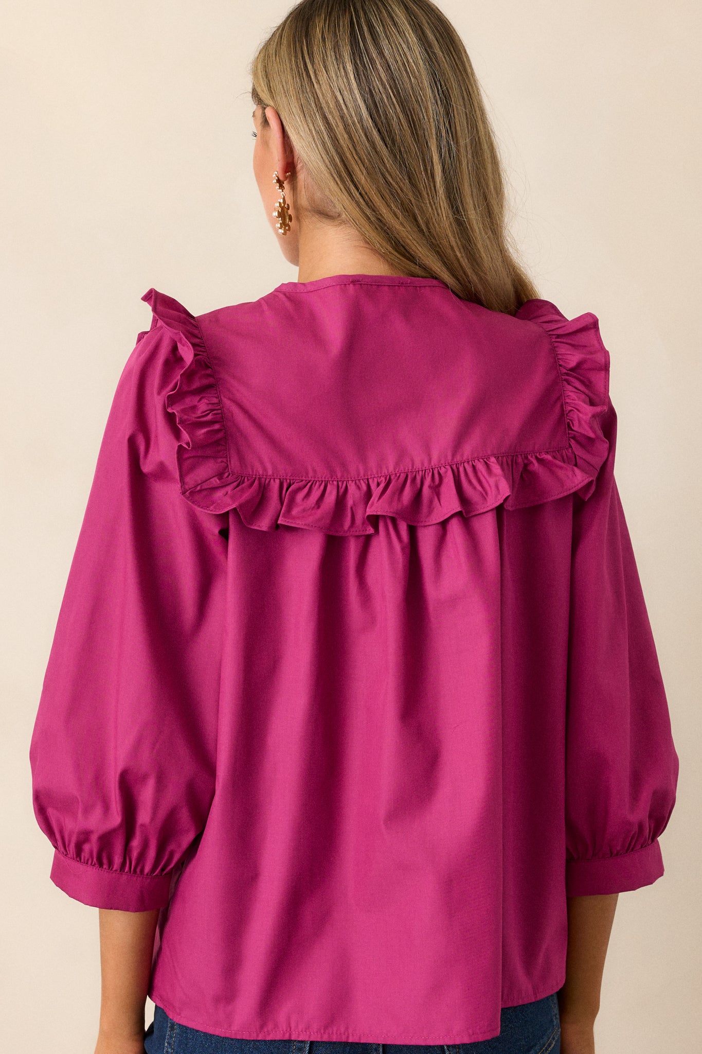 The back view of the dark fuchsia top, highlighting the simple yet elegant design while showcasing the relaxed fit of the fabric.