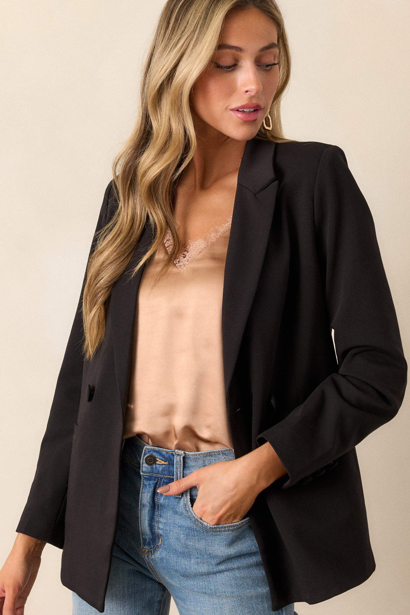 This black blazer features two functional pockets, functional buttons, a lapel collar, lightweight shoulder pads, and a multicolor print lining.