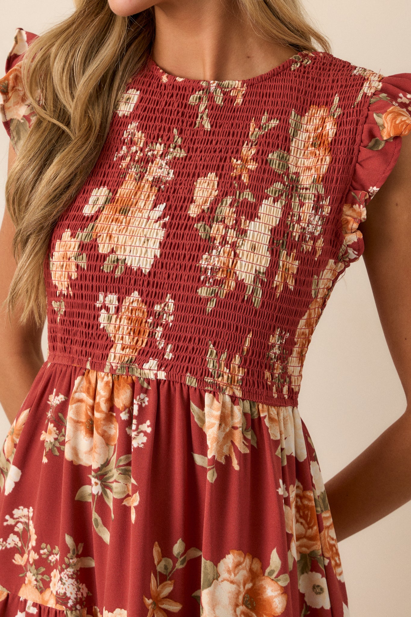 Close-up of the red dress focusing on the fully smocked bodice, the ruffle detailing on the short sleeves, and the texture of the tiered skirt