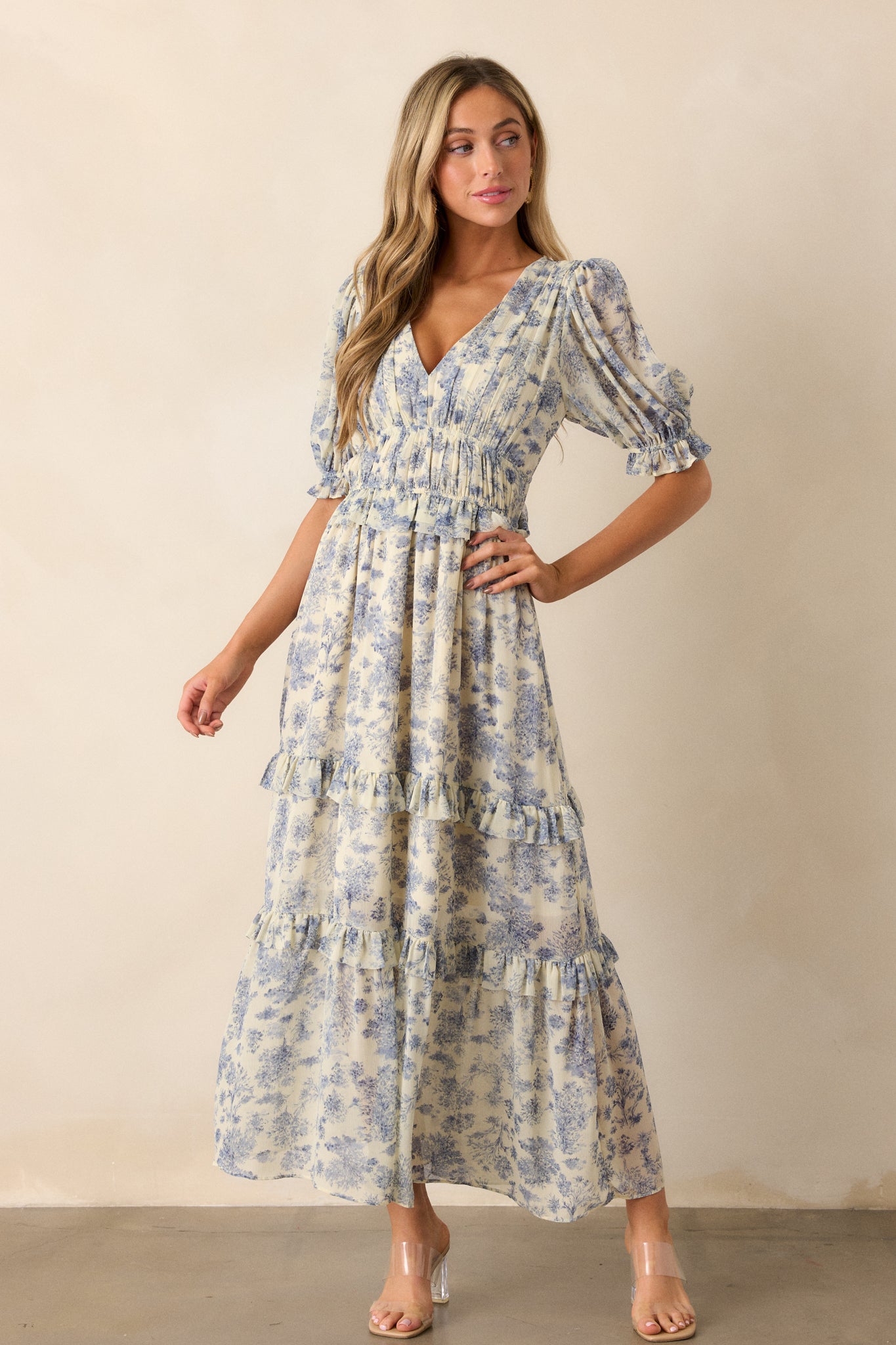 Angled view of the blue dress, highlighting the half-length puff sleeves with elastic cuffs and the two thin elastic waistbands that create a flattering silhouette.