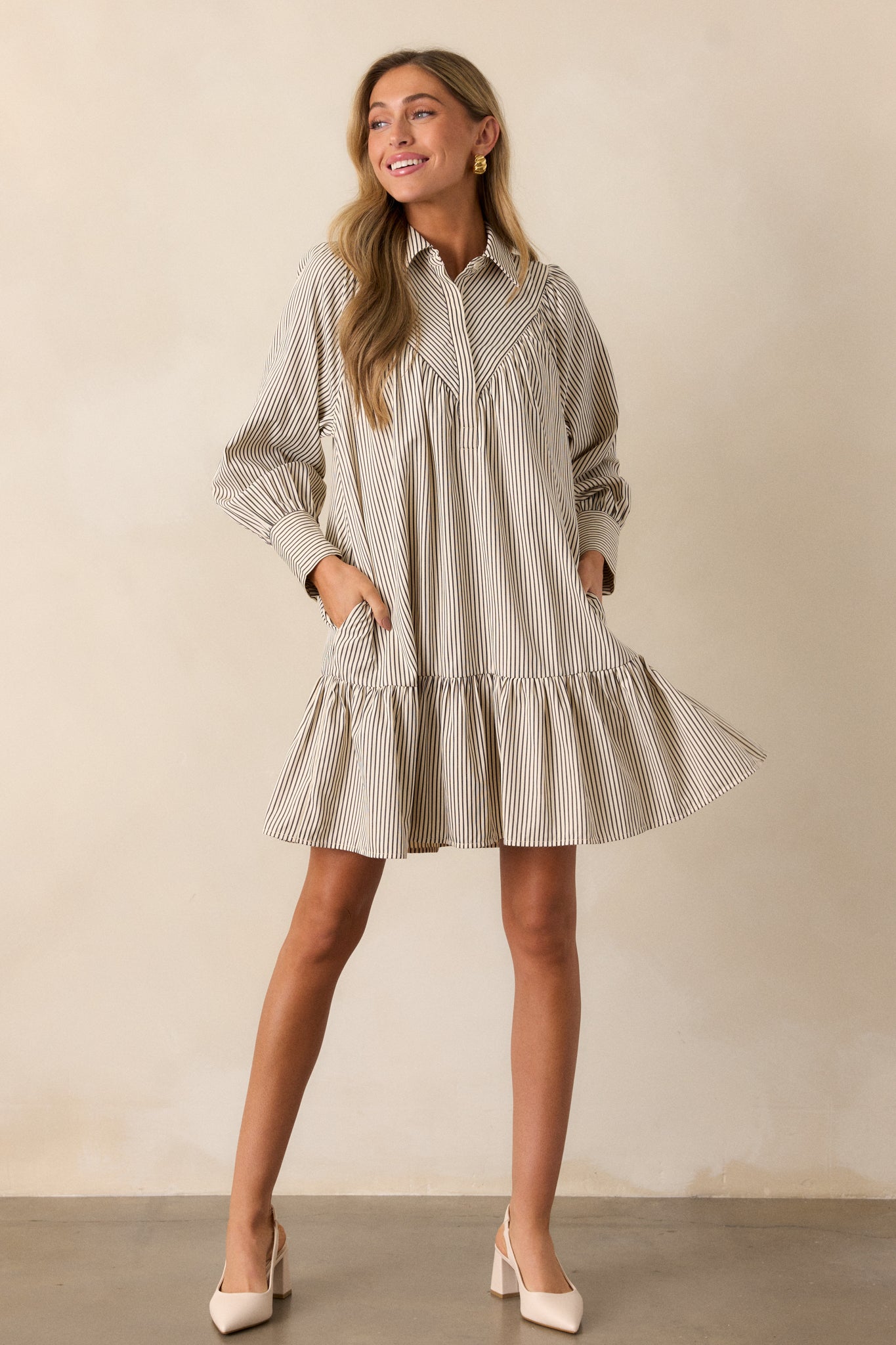 The ivory dress displayed from the front, showcasing the diagonal stripe yoke detailing, long sleeves with cuff detailing, and the contrasting stripe directions on the dress.