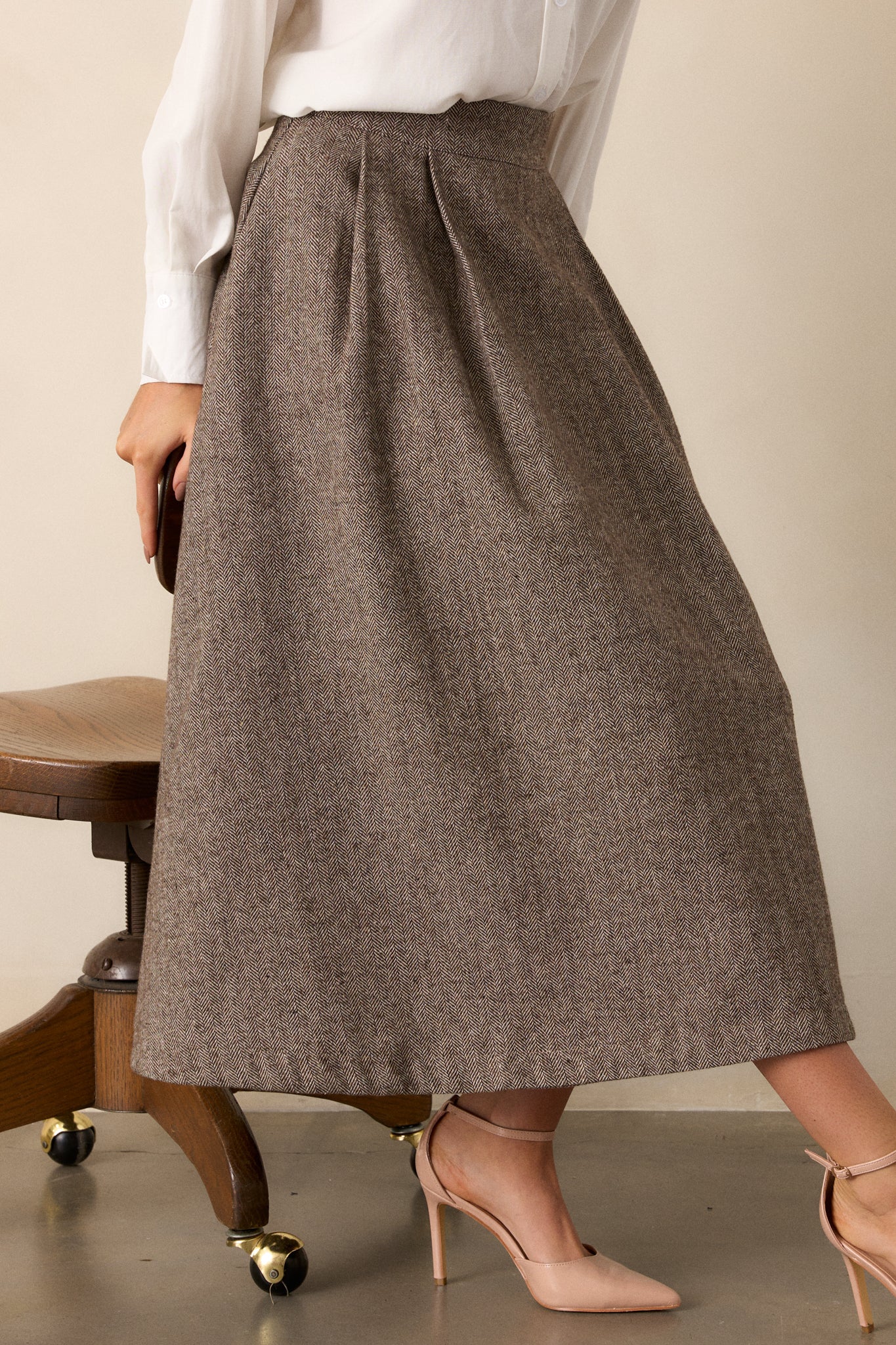 A closer view of the top portion of the skirt, emphasizing the waistline and the subtle herringbone print that adds texture.