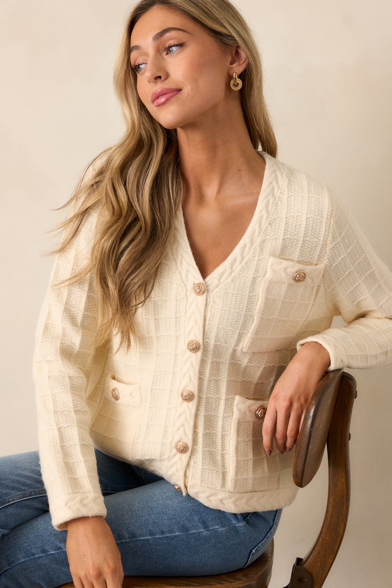 Close-up of the upper section, emphasizing the v-neckline, braided knit hems, and the intricate cable knit grid design near the shoulders.