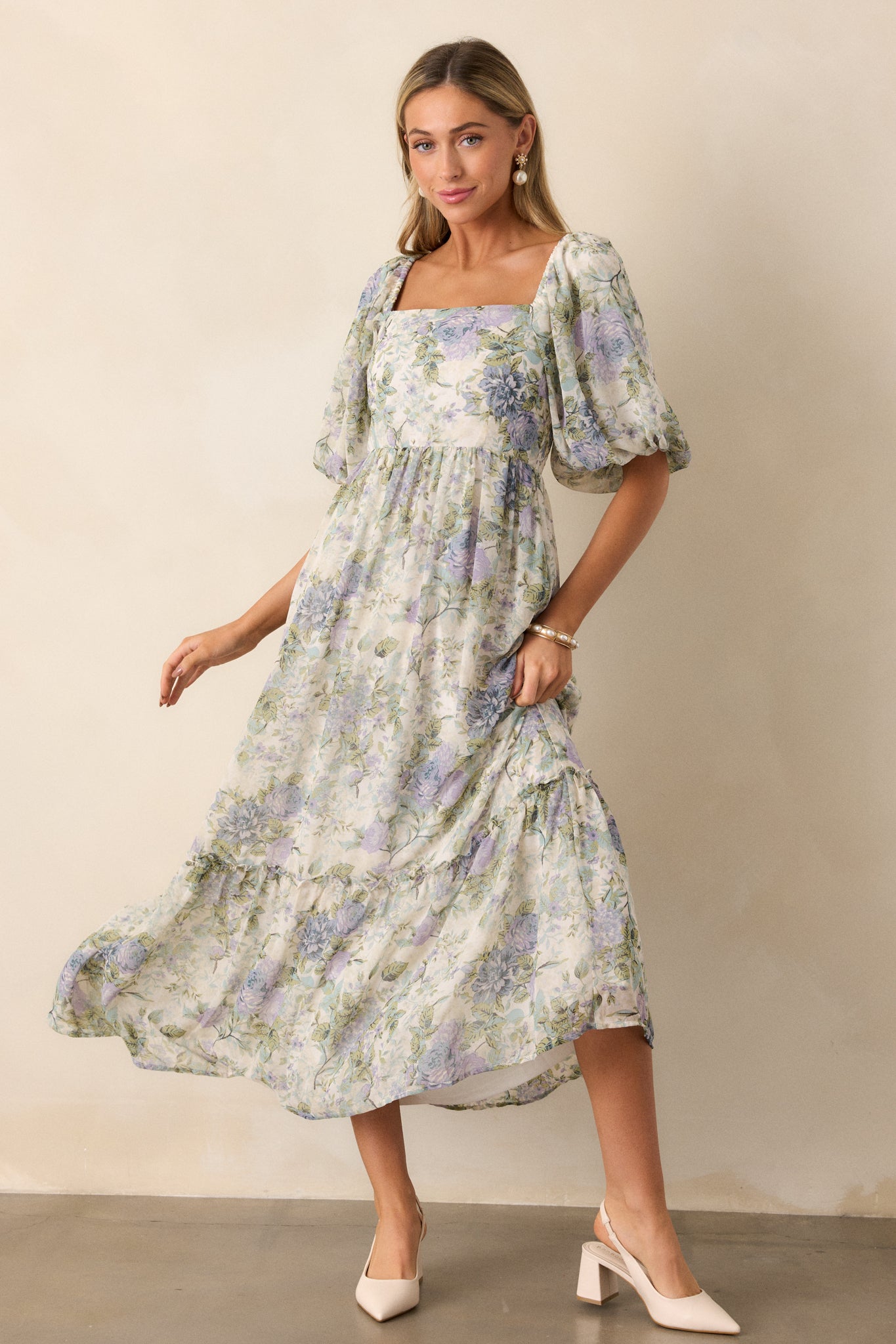 A full body shot from a side angle, showcasing the ruffle tiered accent along the hem and the elegant flow of the fabric as it drapes gracefully.