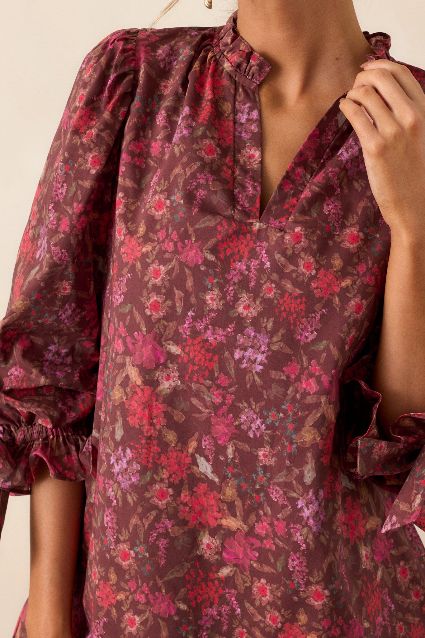 Close-up of the beautiful floral pattern on the burgundy mini dress, showcasing the vibrant colors and detailed design.