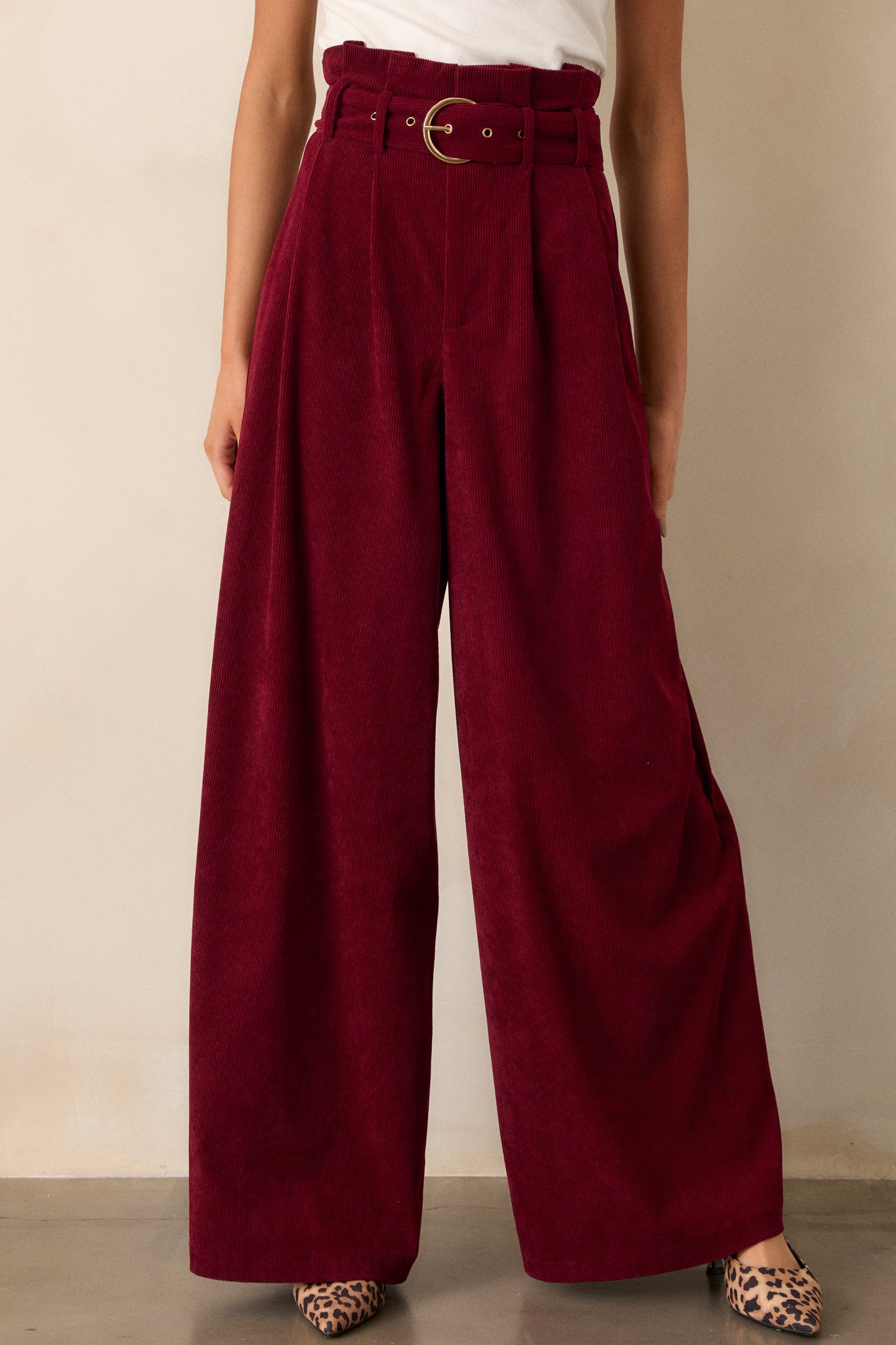 These burgundy pants feature a paper bag style waistline, an adjustable belt, a zipper closure, and very flowy legs.