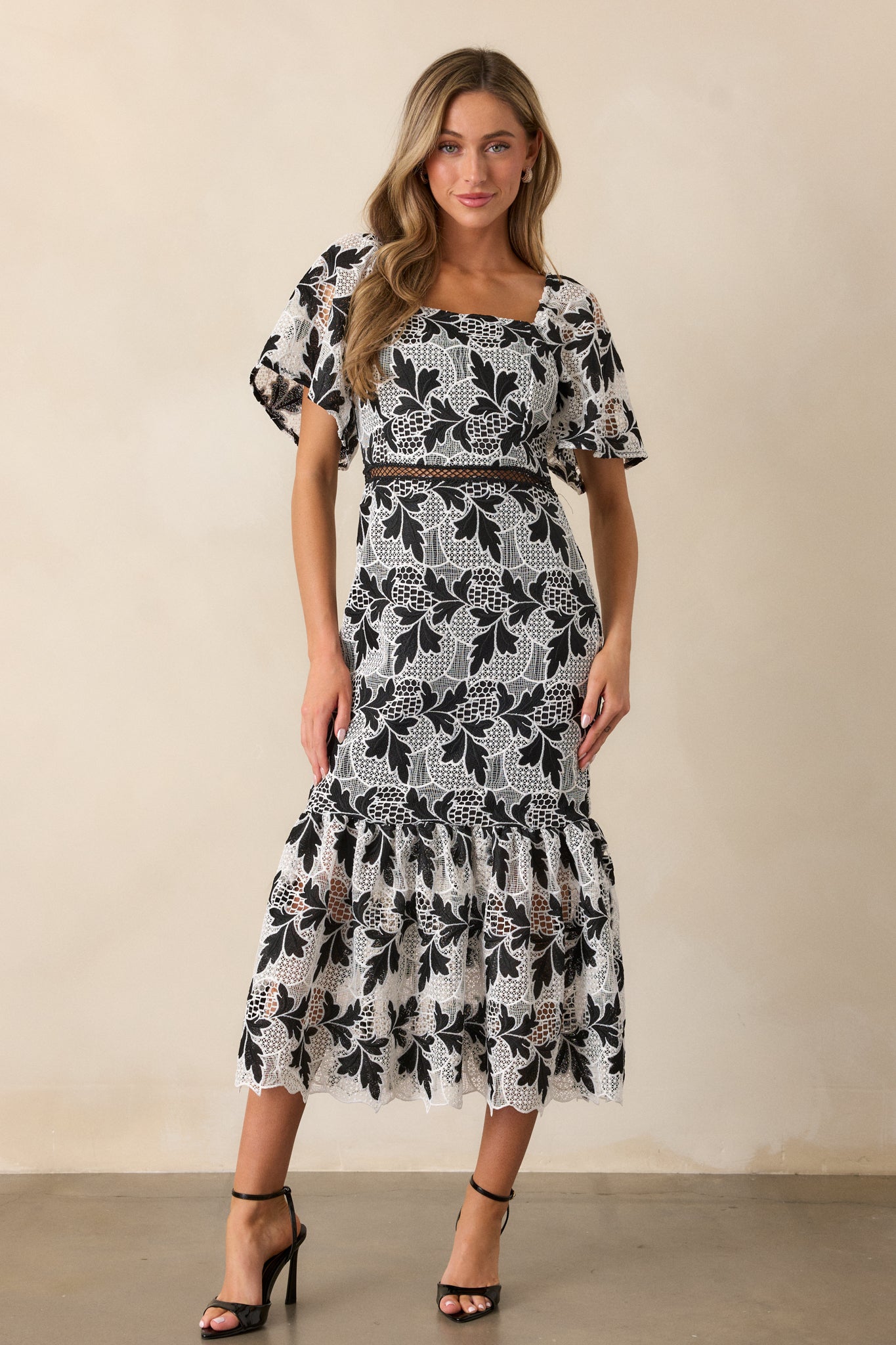 Front view of the dress, showcasing the layered tiers and how the embroidered design flows gracefully down to the hem.