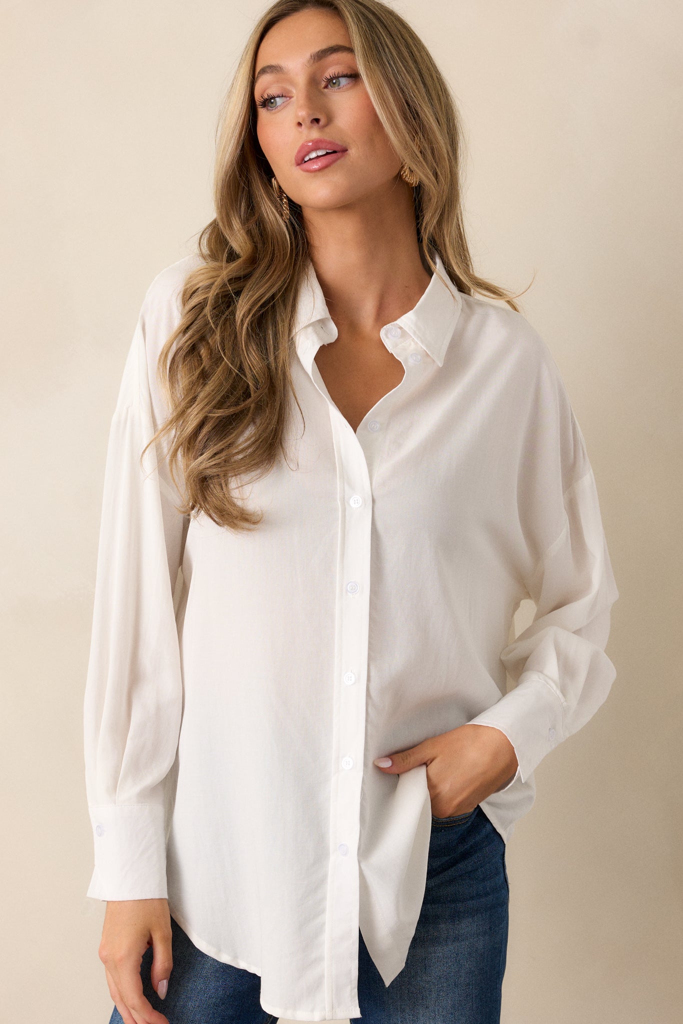 A full-length view of the top, showcasing the collared neckline and buttoned cuffs on the long sleeves. The dropped shoulders add to the relaxed and comfortable fit of the top, and the buttons down the front are clearly visible.