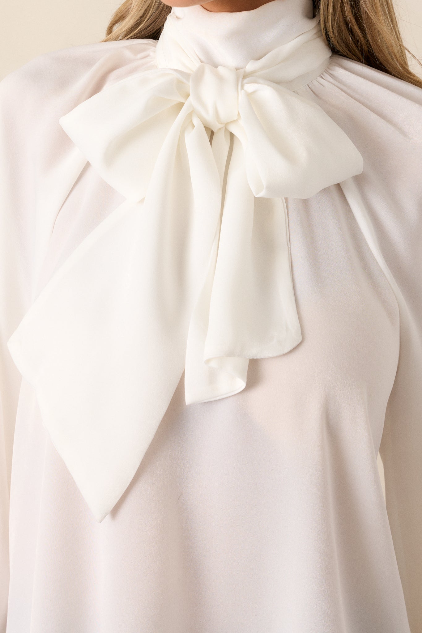 A close-up view of the self-tie around the neck and the flowy fabric of the top. 