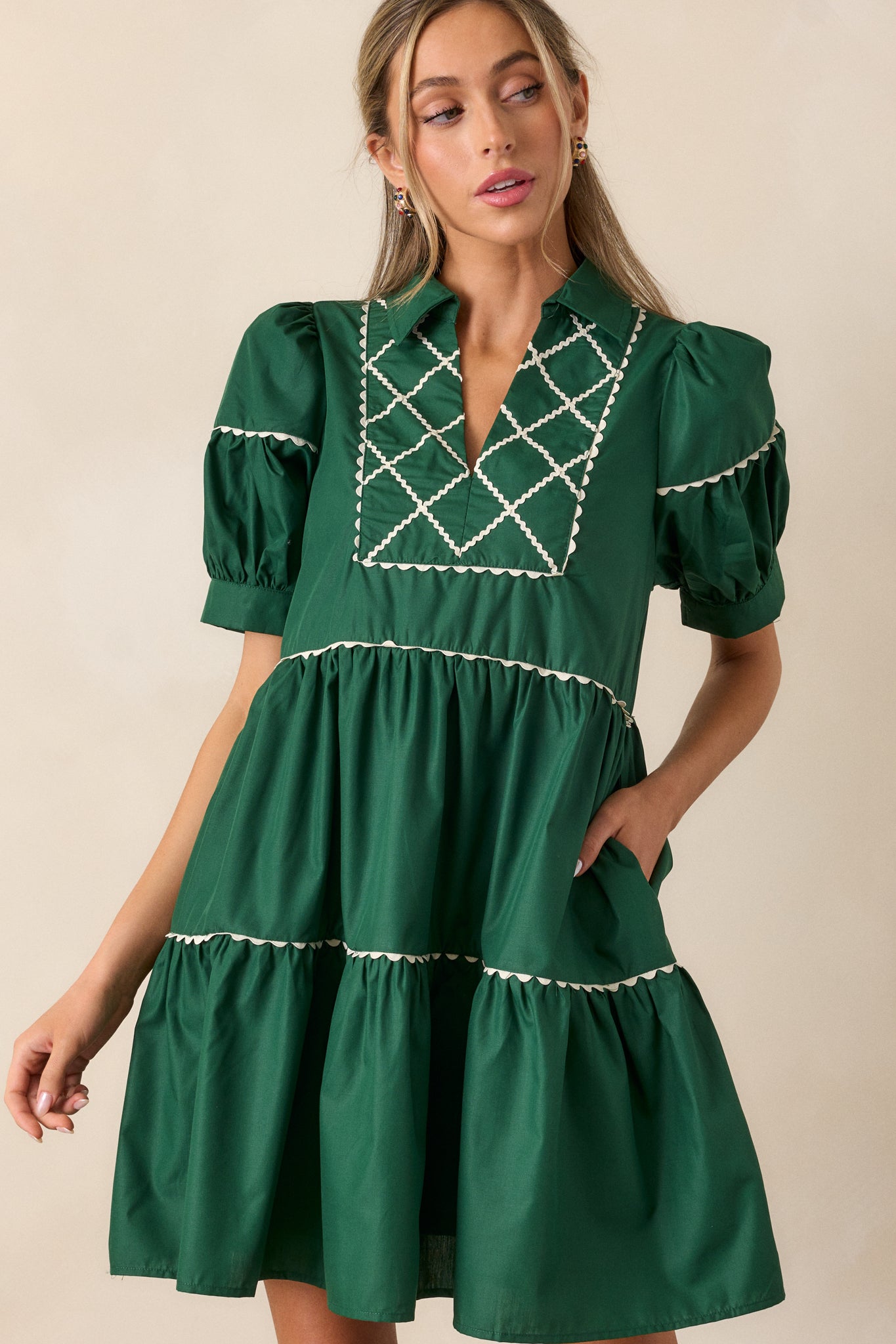 Close-up of the collared split neckline and cross stitch yoke detail on the emerald mini dress, showing intricate white stitching.