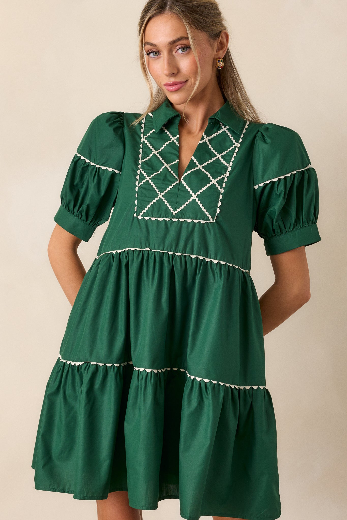 Detailed view of the puff sleeves on the emerald mini dress, highlighting the contrast between the emerald fabric and white stitching