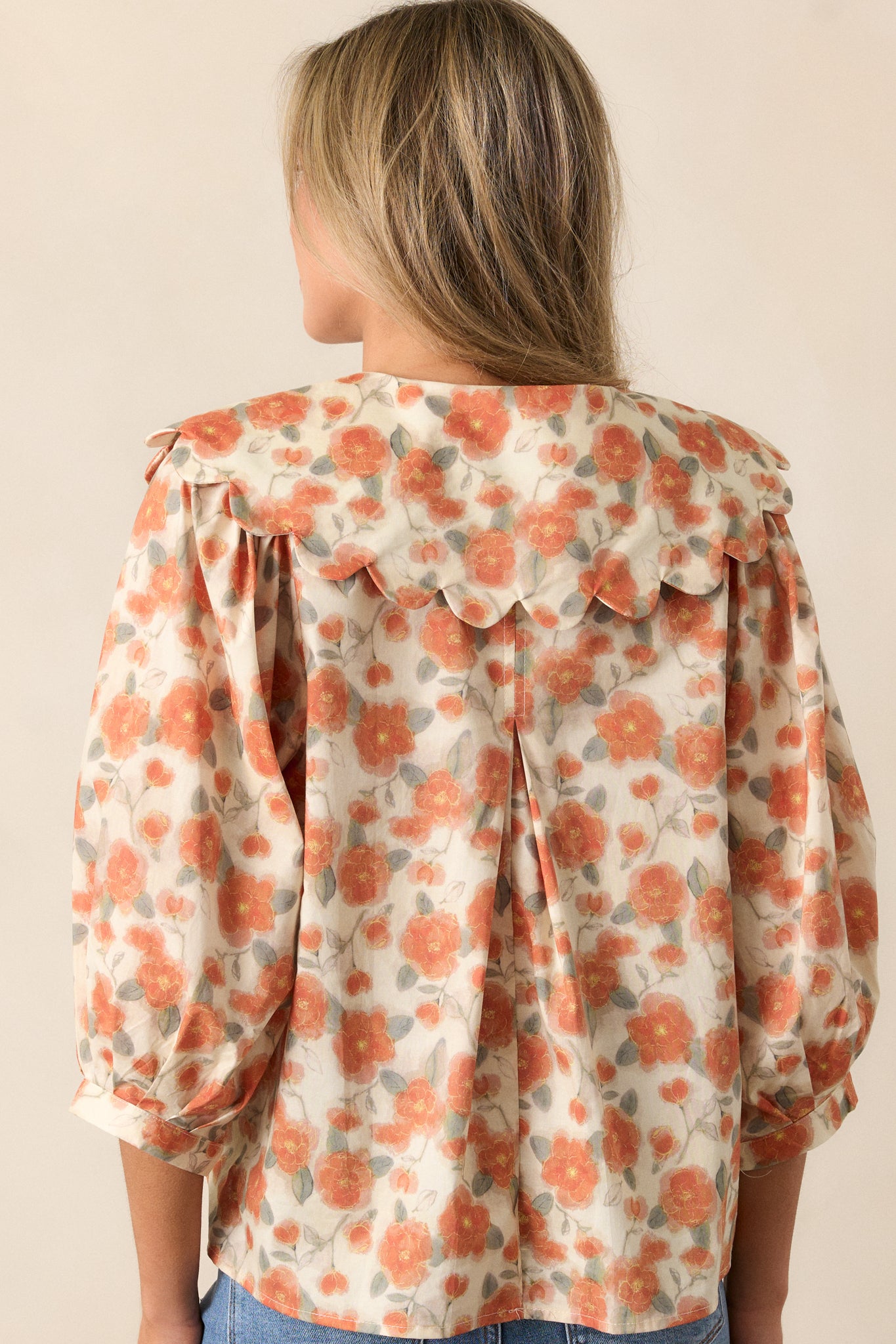 Back view of the apricot blouse with a relaxed fit, highlighting the floral pattern and 3/4 sleeves.