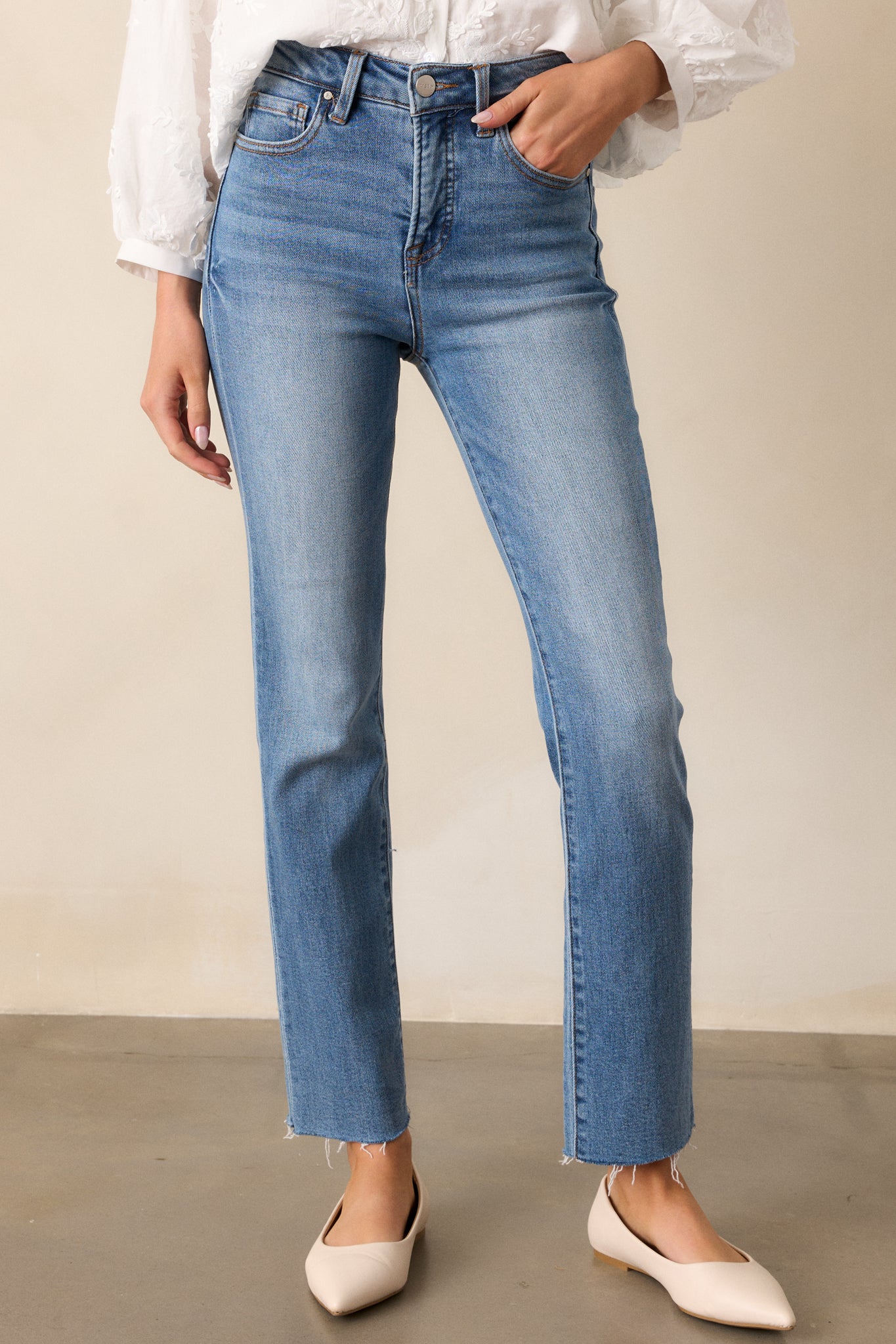 Another cropped shot of the jeans, emphasizing the clean straight leg design and medium wash.