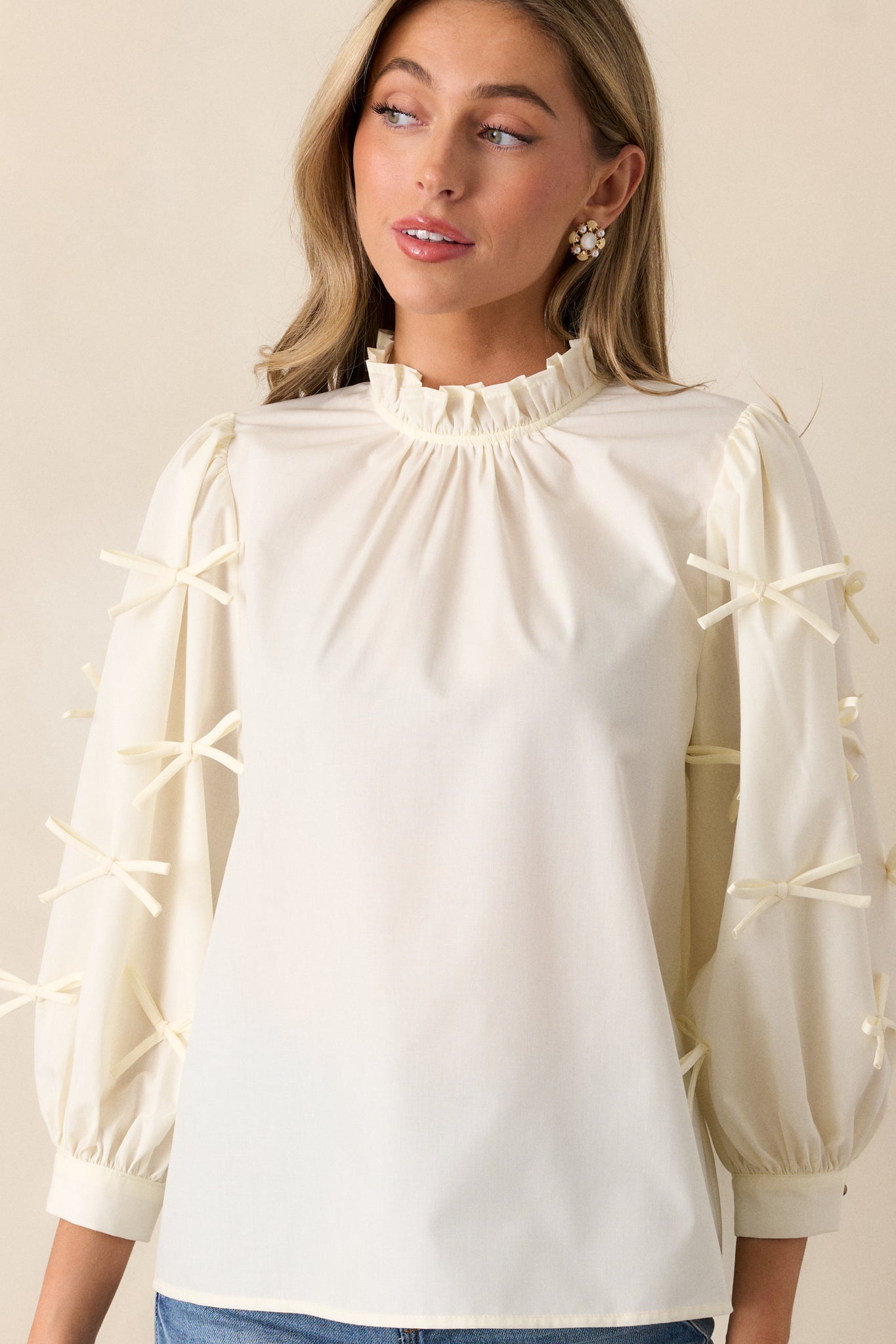 Mid-shot of the blouse’s 3/4 sleeve, focusing on the bow detail and buttoned cuff for an elegant touch.