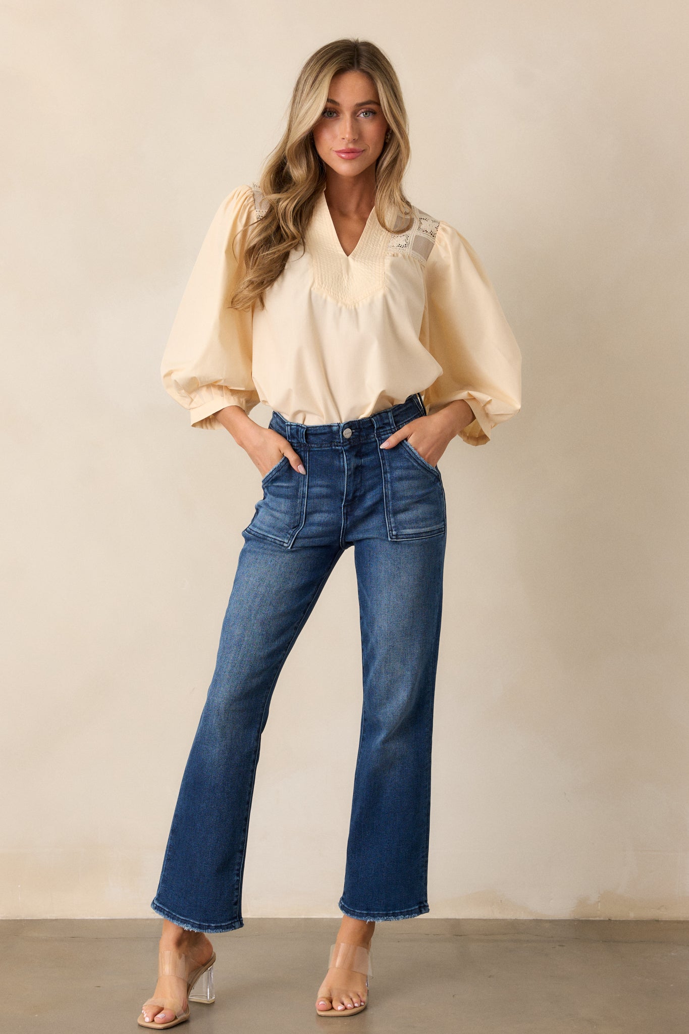 Full-length view of the jeans, highlighting the high waist and the smooth dark wash, with a glimpse of the front and back pockets.