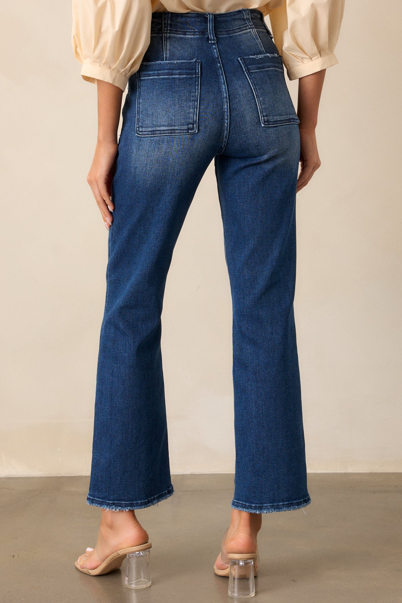 Back view of the jeans, showcasing the high waisted cut, functional back pockets, and smooth, even dark wash across the back.