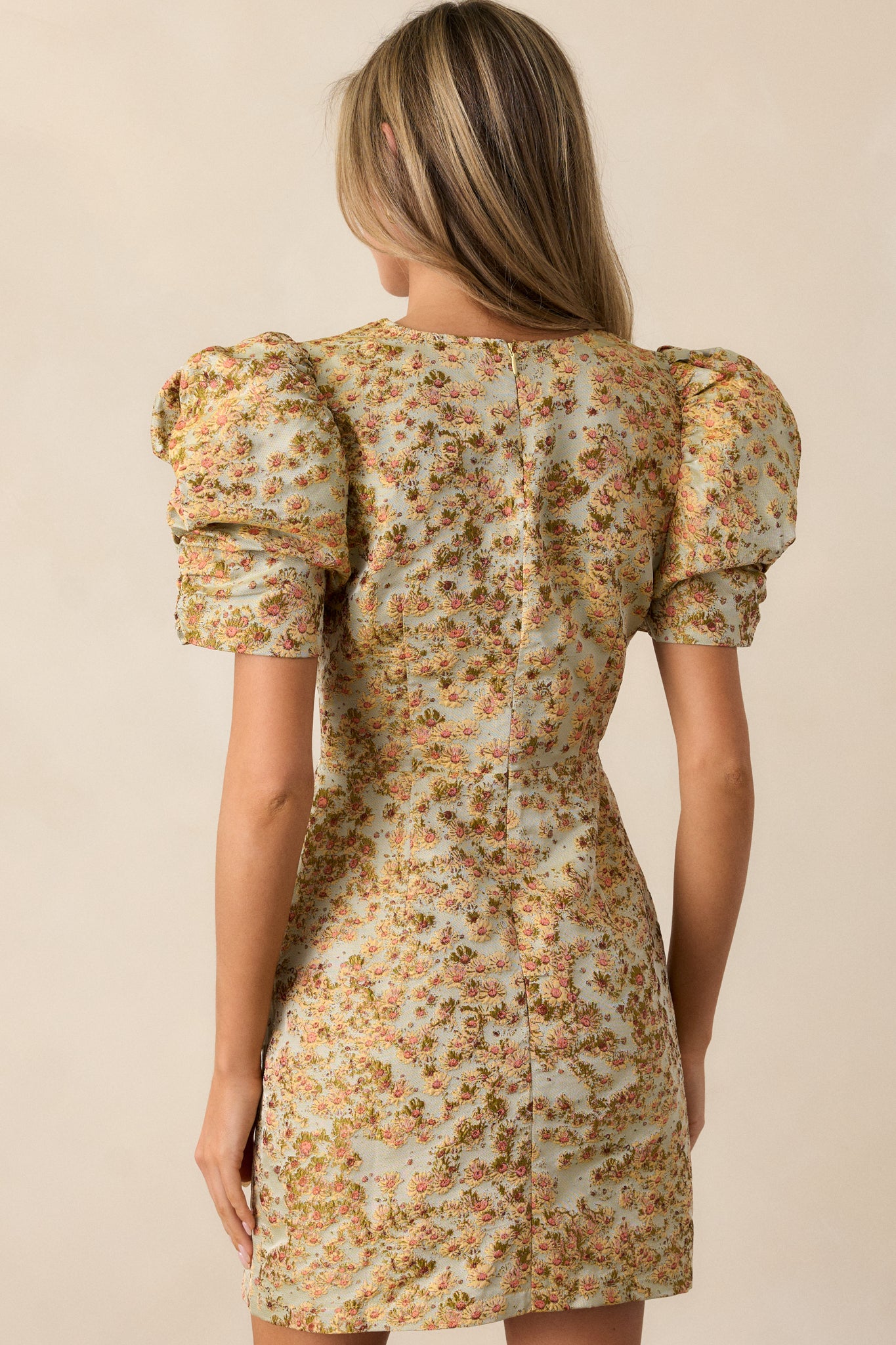 Back view of the honey dress, showcasing the discrete back zipper and the smooth, fitted design with short puff sleeves and floral detailing.