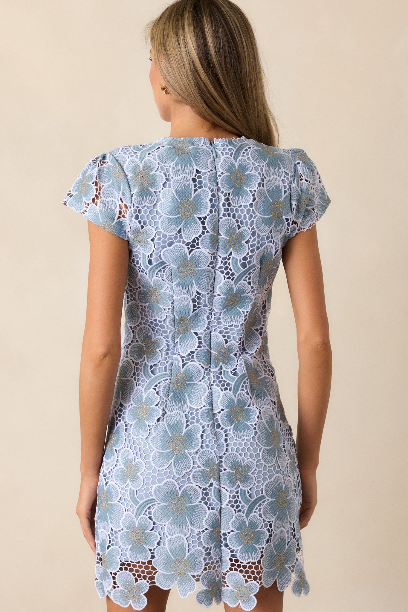 Back view of the dress, showing the discrete zipper and the smooth sky blue fabric extending to mini length with no interruption in the dress’s flow.