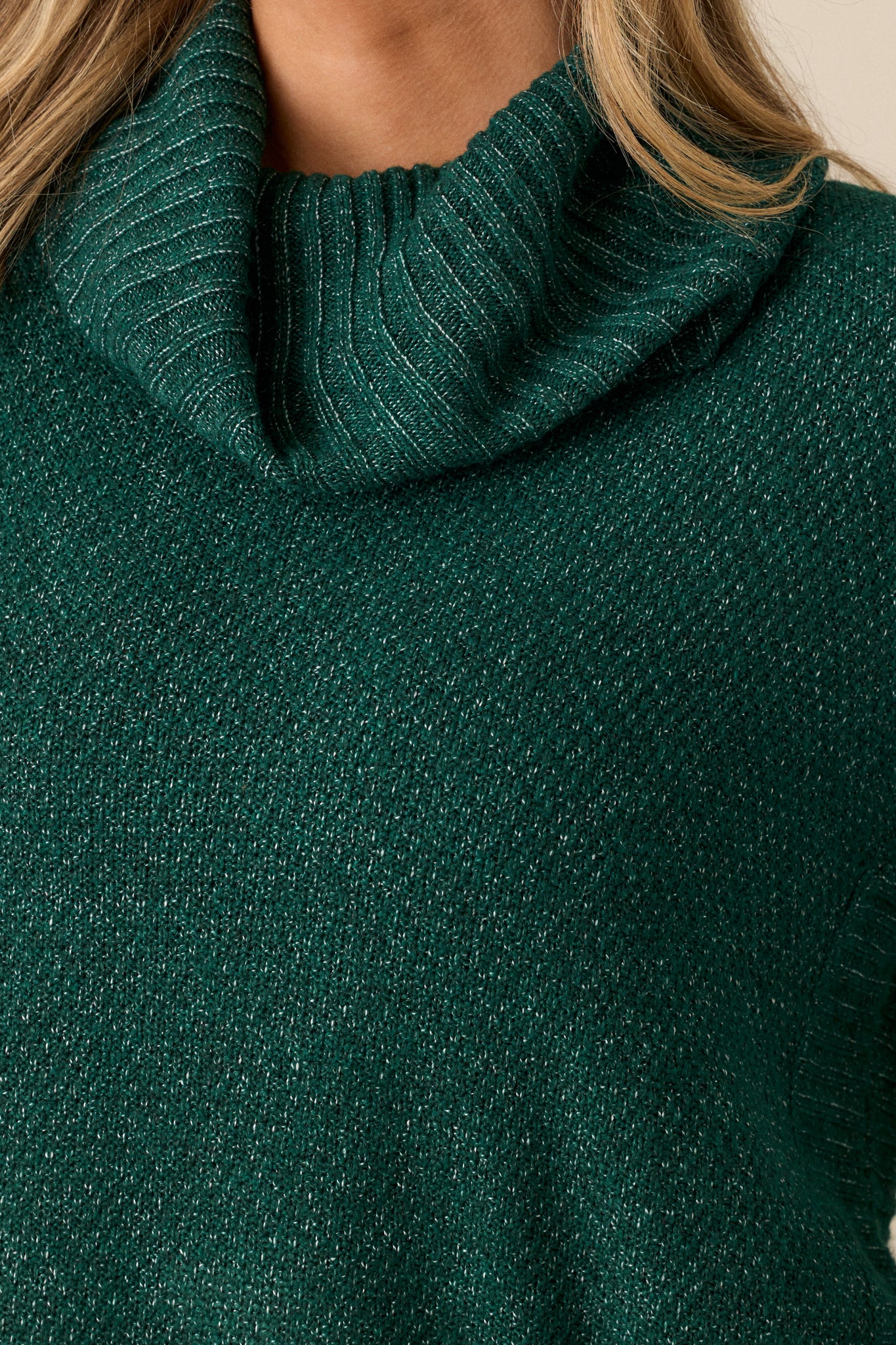 Detailed close-up of the speckled coloring and knit texture on the hunter green sweater.