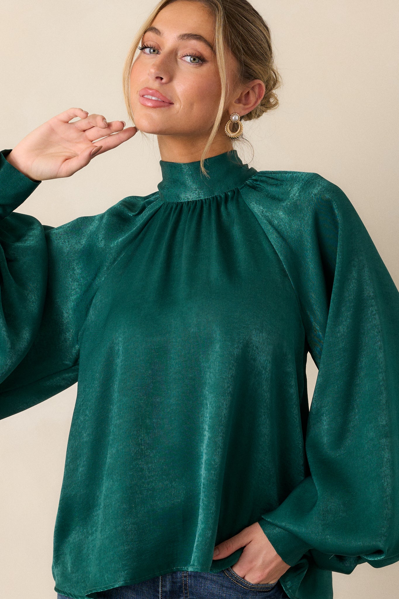 A cropped view focusing on the high neckline and self-tie bow at the front, showcasing the refined detailing and elegant lines.