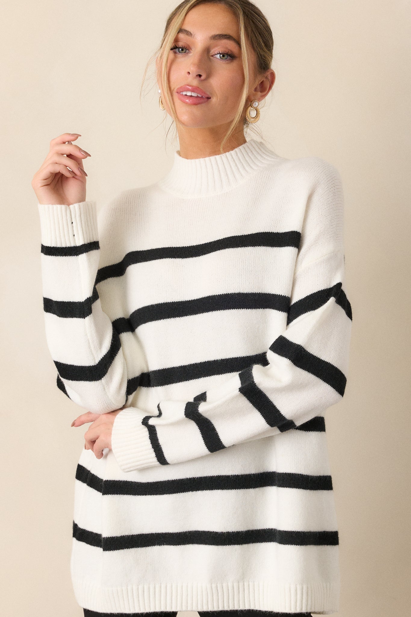 Close-up of the sweater’s mock neck and upper section, emphasizing the ribbed hem detail and the first few black horizontal stripes.